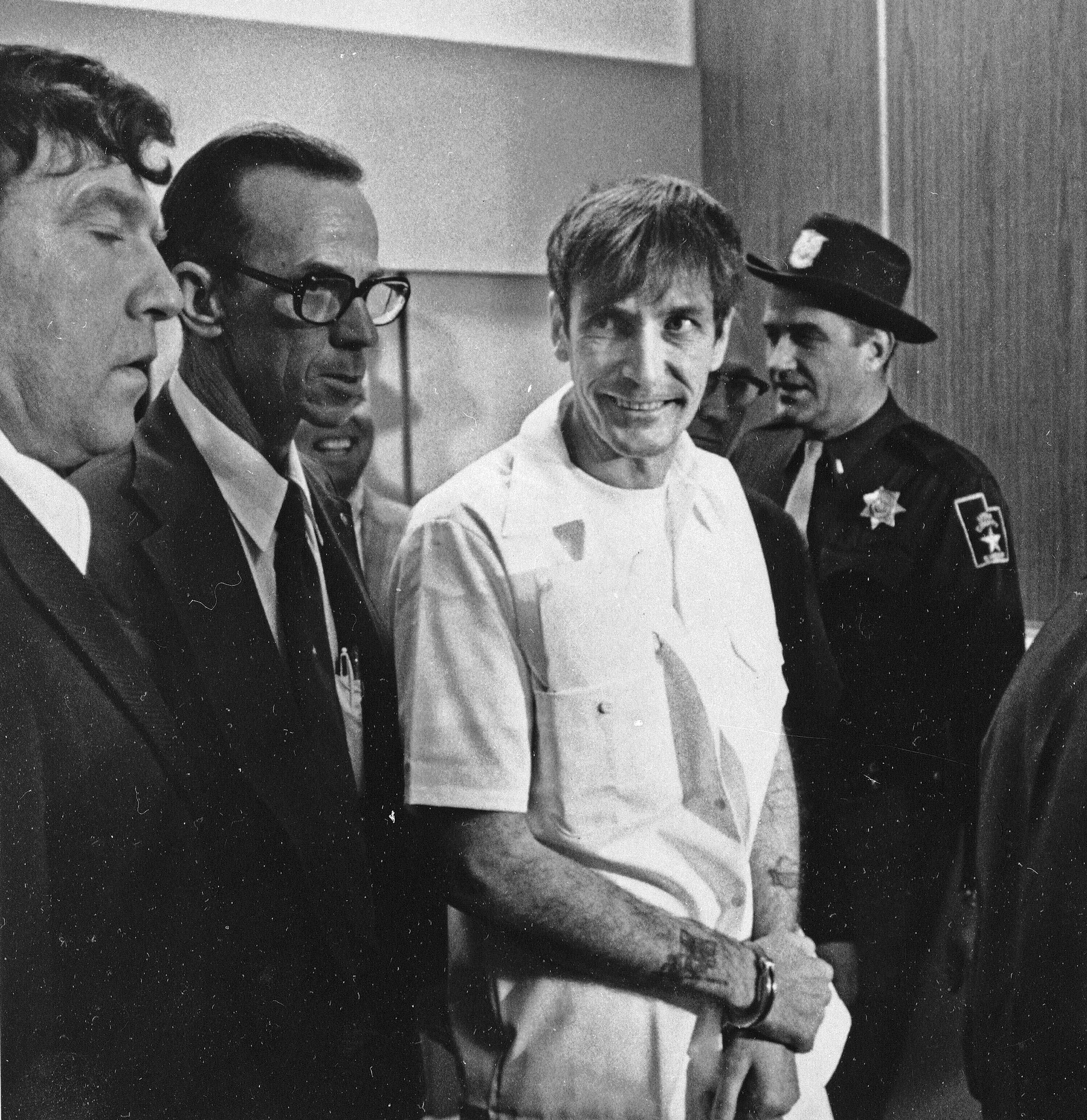 Convicted murderer Gary Mark Gilmore arrives, heavily guarded, at the 4th District Court in Provo, Utah, on Dec. 1, 1976.