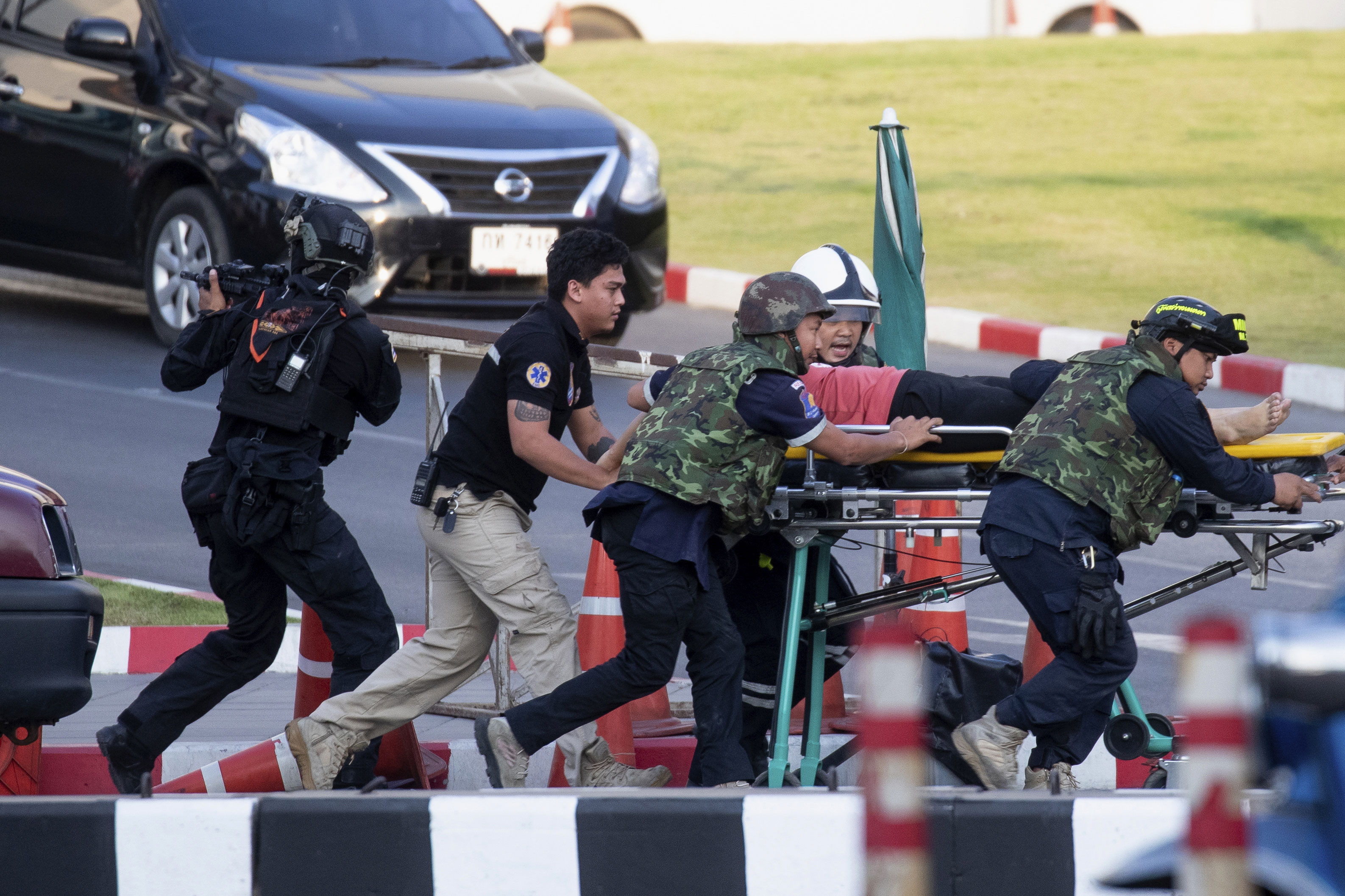 Armed commando soldiers carry a person out of Terminal 21 Korat mall