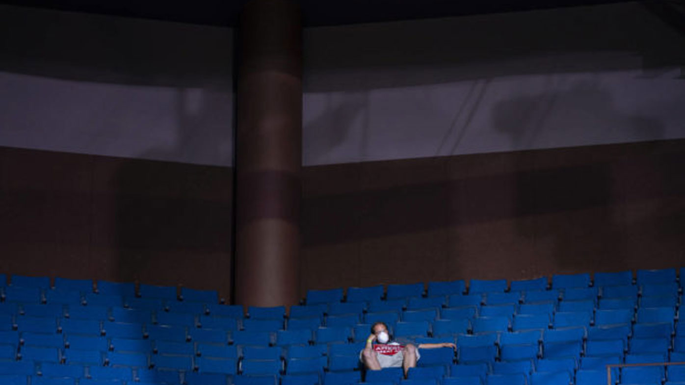 A Trump supporter waits for the president to arrive in an empty stand.