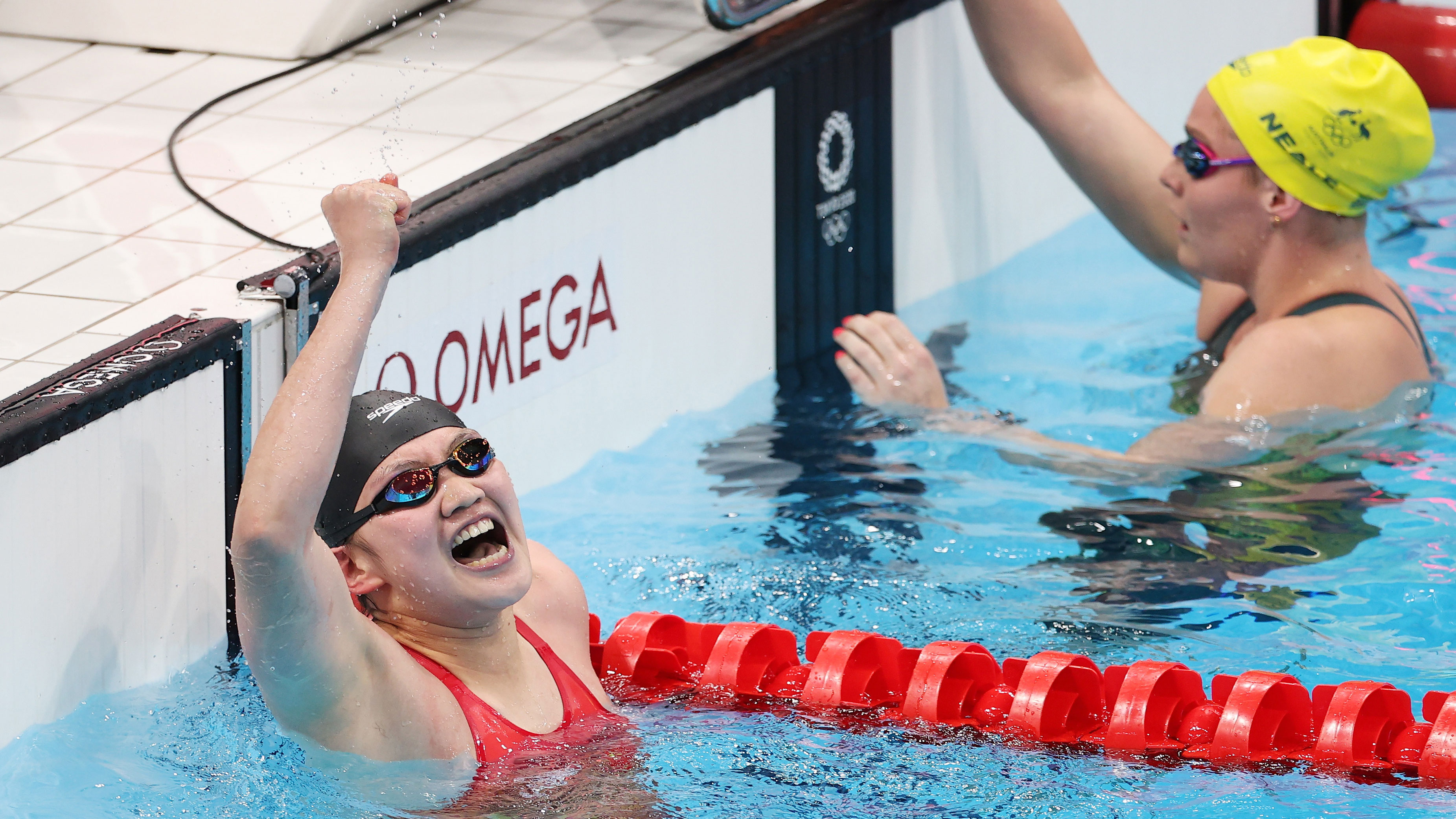 Chinese swimmer Li Bingjie celebrates after touching the wall first, as Leah Neale finishes off Australia's bronze medal swim.