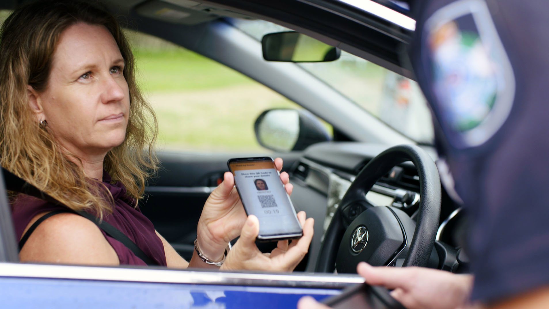 A driver presenting their digital licence app to a Queensland police officer.