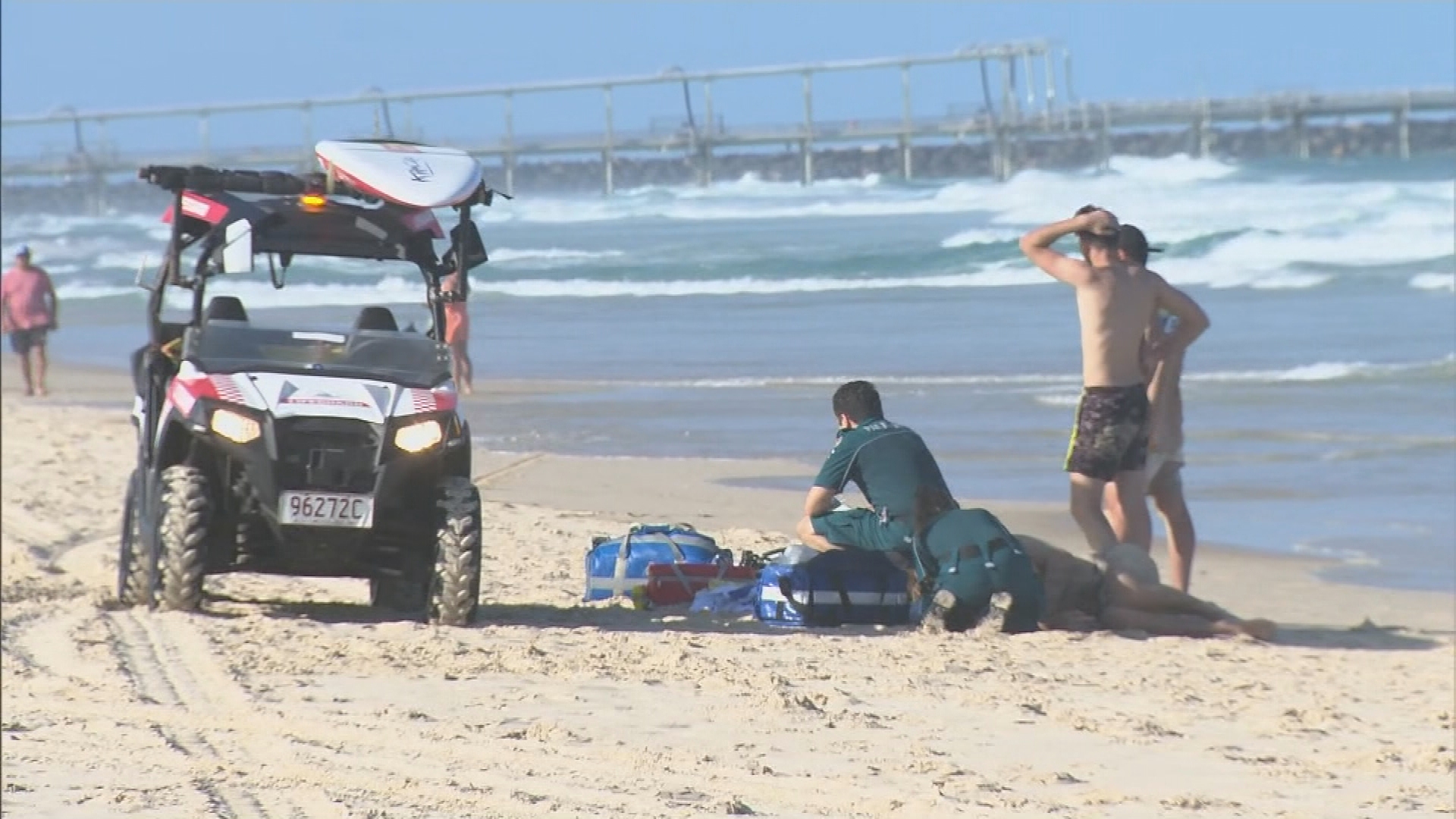 A man in his 20s has died and two others were taken to hospital, after three men were pulled from the water at The Spit on the Gold Coast.