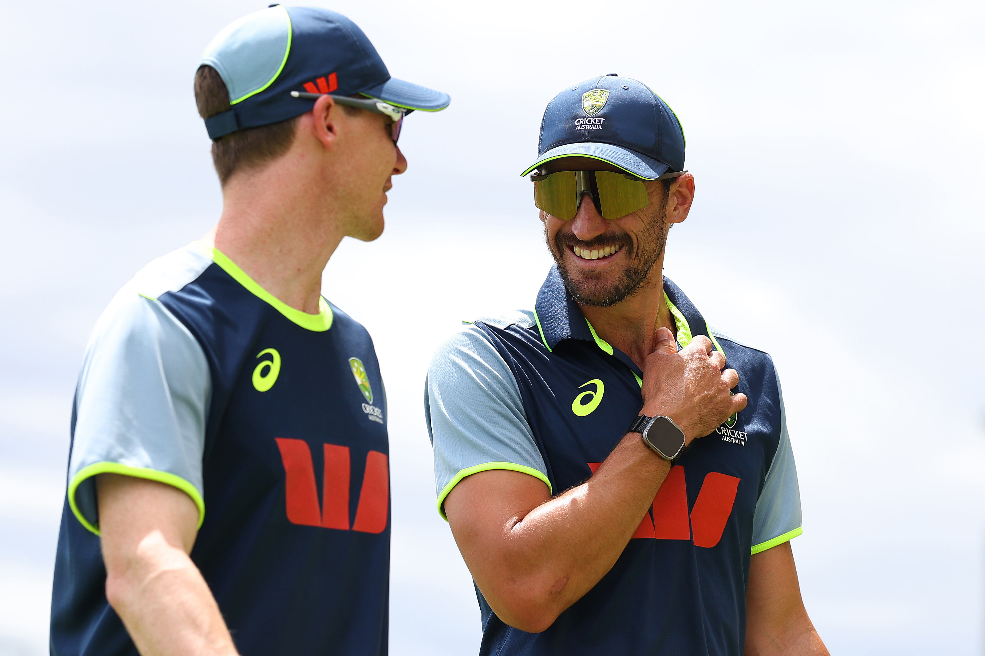 PERTH, AUSTRALIA - NOVEMBER 19: Brendan Doggett and Mitchell Starc walk from the nets area after nearby lightning halts the practice session during an Australia nets session at Perth Stadium on November 19, 2025 in Perth, Australia. (Photo by Paul Kane/Getty Images)