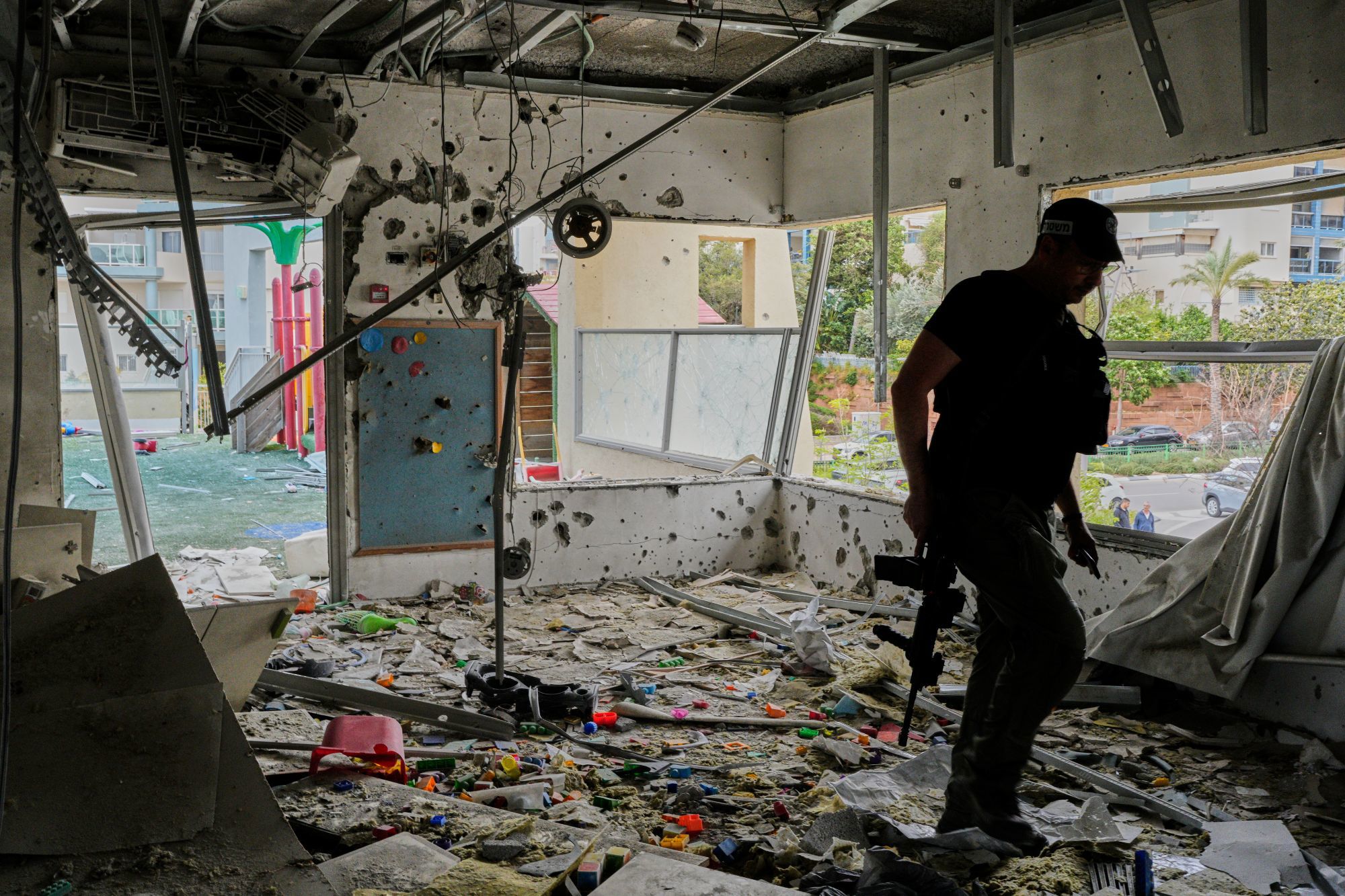 An Israeli policeman walks in a kindergarten hit by fragments 