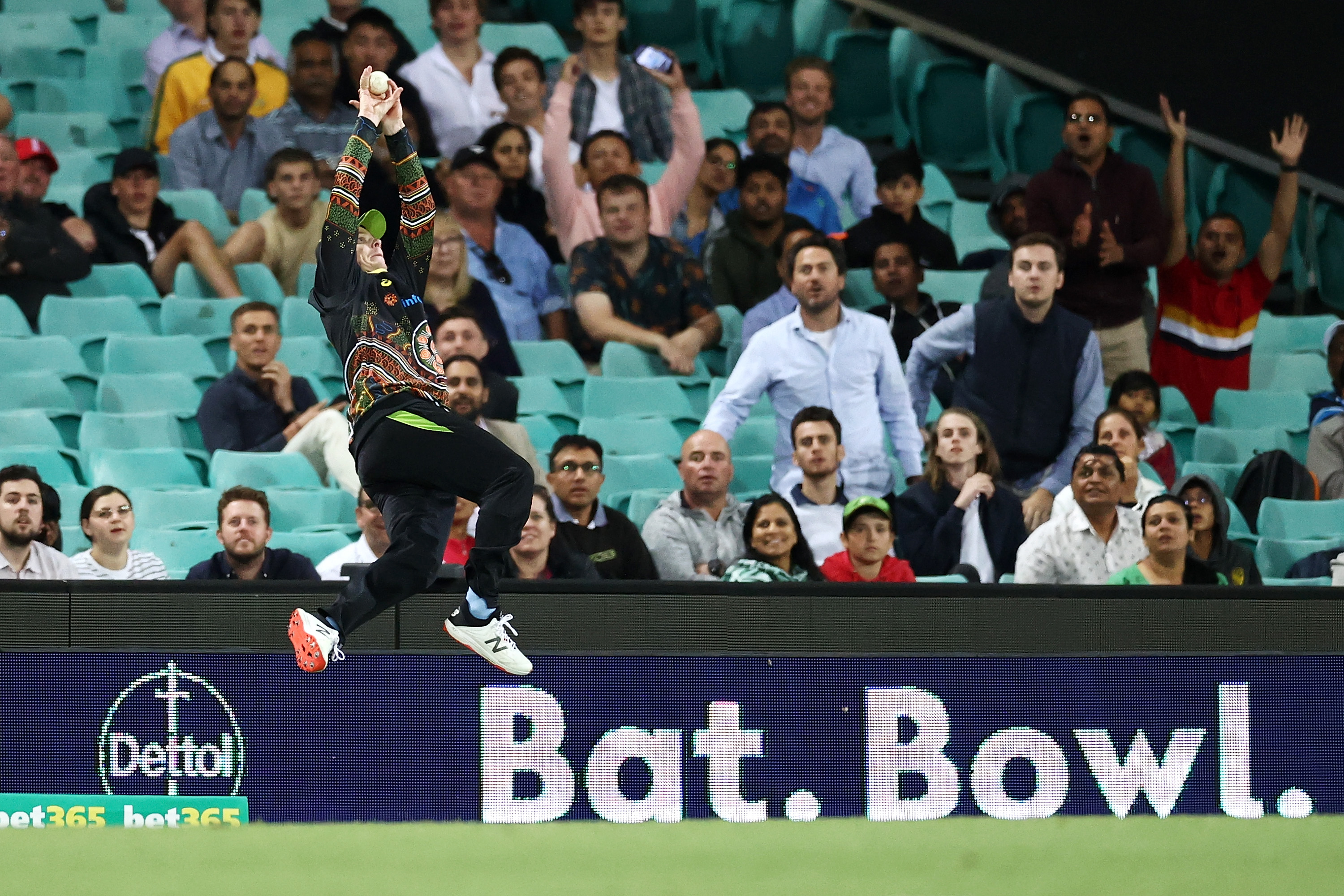 Steve Smith of Australia attempts to catch Virat Kohli of India.