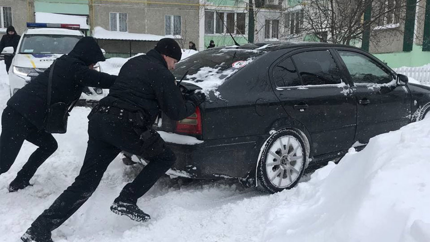 Police in Chernihiv help a car get moving in deep snow.