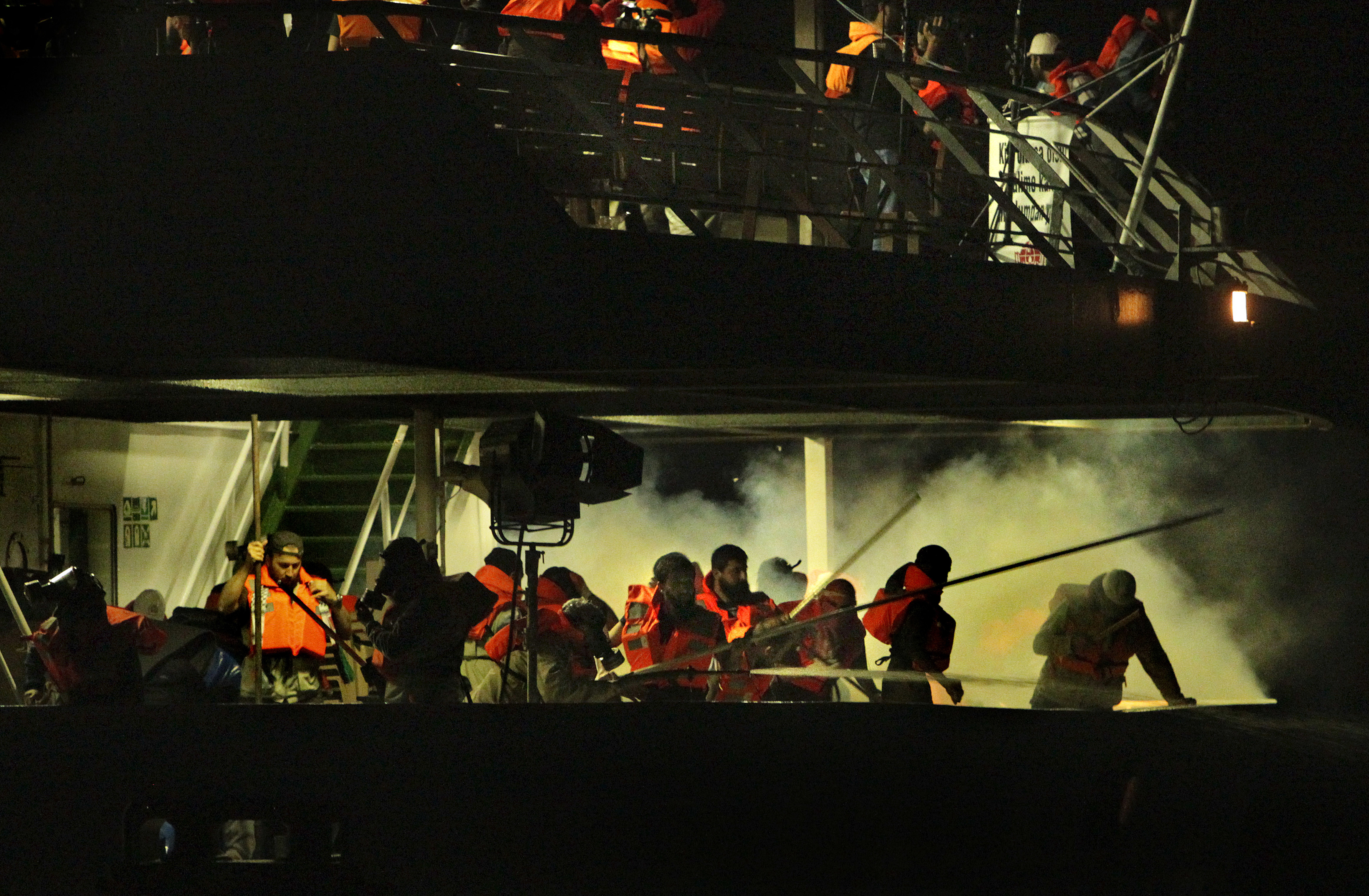 Passengers on the second deck of the Turkish passenger ship the Mavi Marmara run as they are surrounded by smoke from the tear gas fired from Israeli assault boats shortly after the men had completed their evening prayer. The Israeli navy attacked 6 ships of the Freedom Flotilla headed for Gaza in the early hours of Monday 31st of May, 2010.