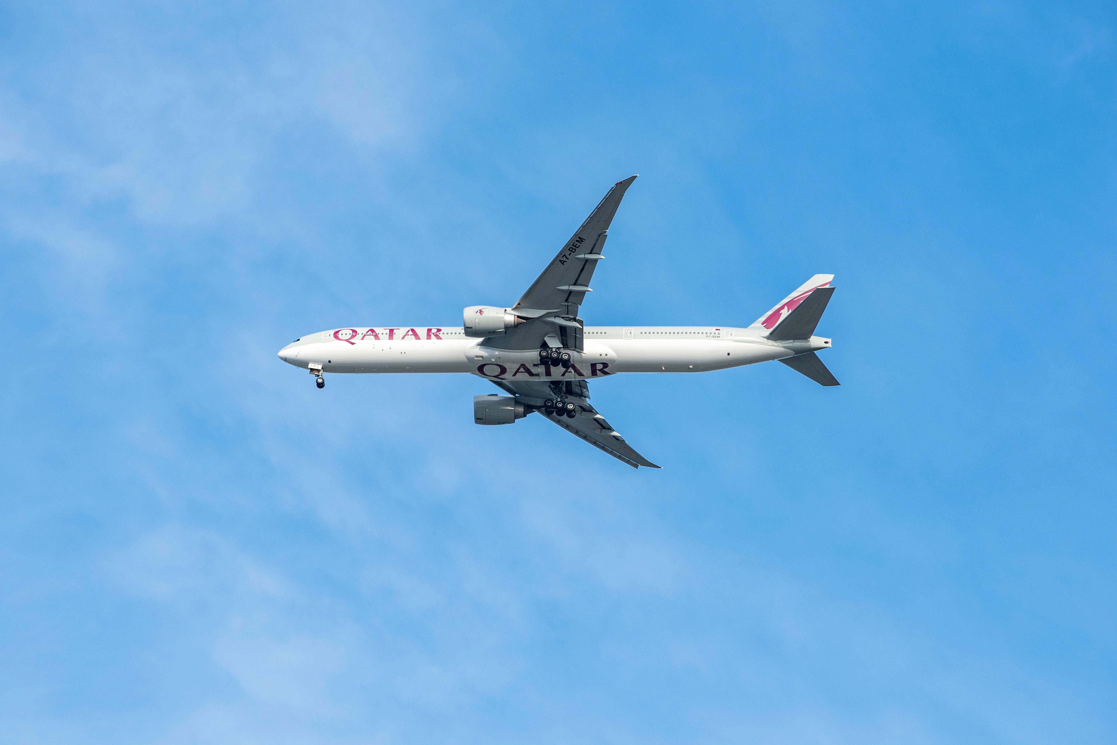 A Qatar Airways plane flies over Brisbane Airport