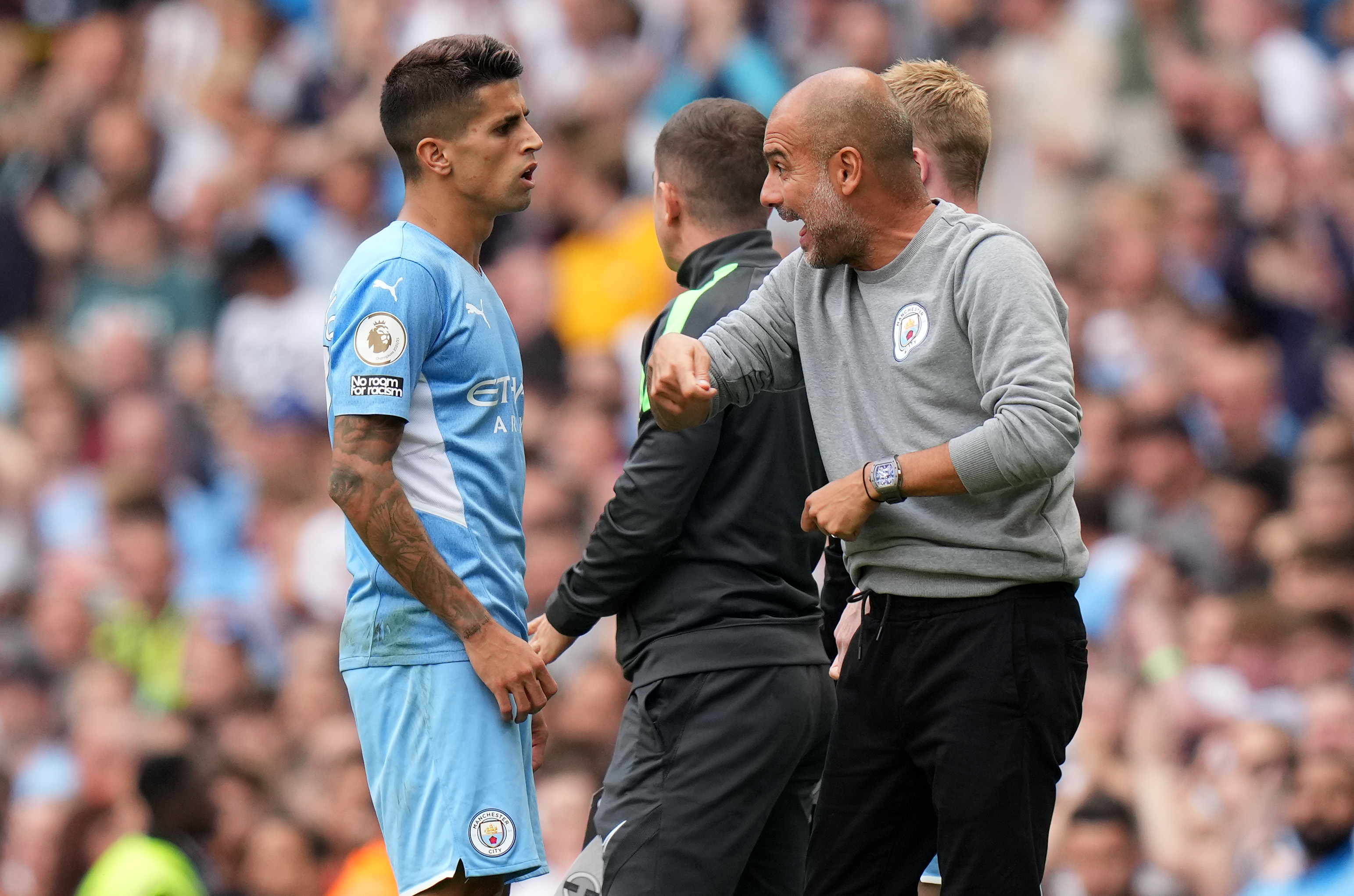 Pep Guardiola, manager of Manchester City talks with Joao Cancelo.