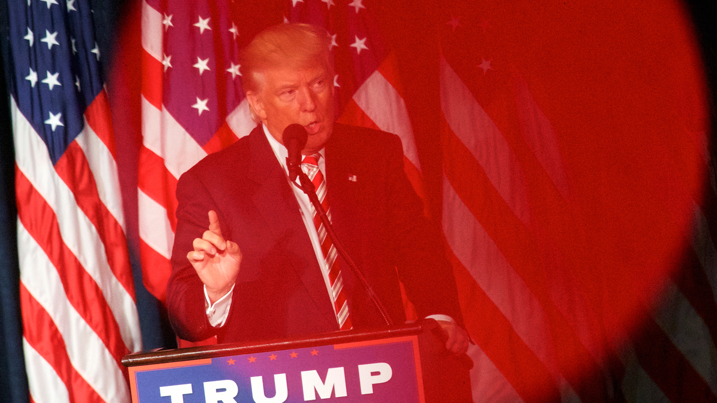 Donald J. Trump is seen through the red light of a videographer's camera while delivering a speech at The Union League of Philadelphia