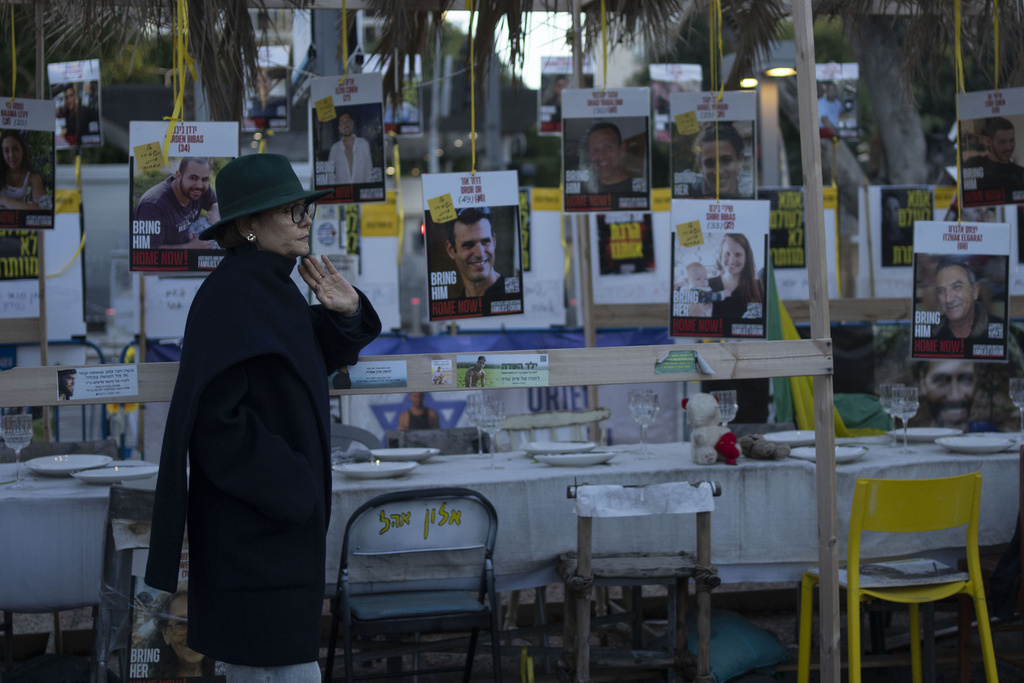 Una mujer mira una exhibición de sillas vacías que representan rehenes retenidos por el grupo militante Hamás en la Franja de Gaza en Tel Aviv, Israel, el viernes 24 de enero de 2025. (Foto AP/Maya Alleruzzo)