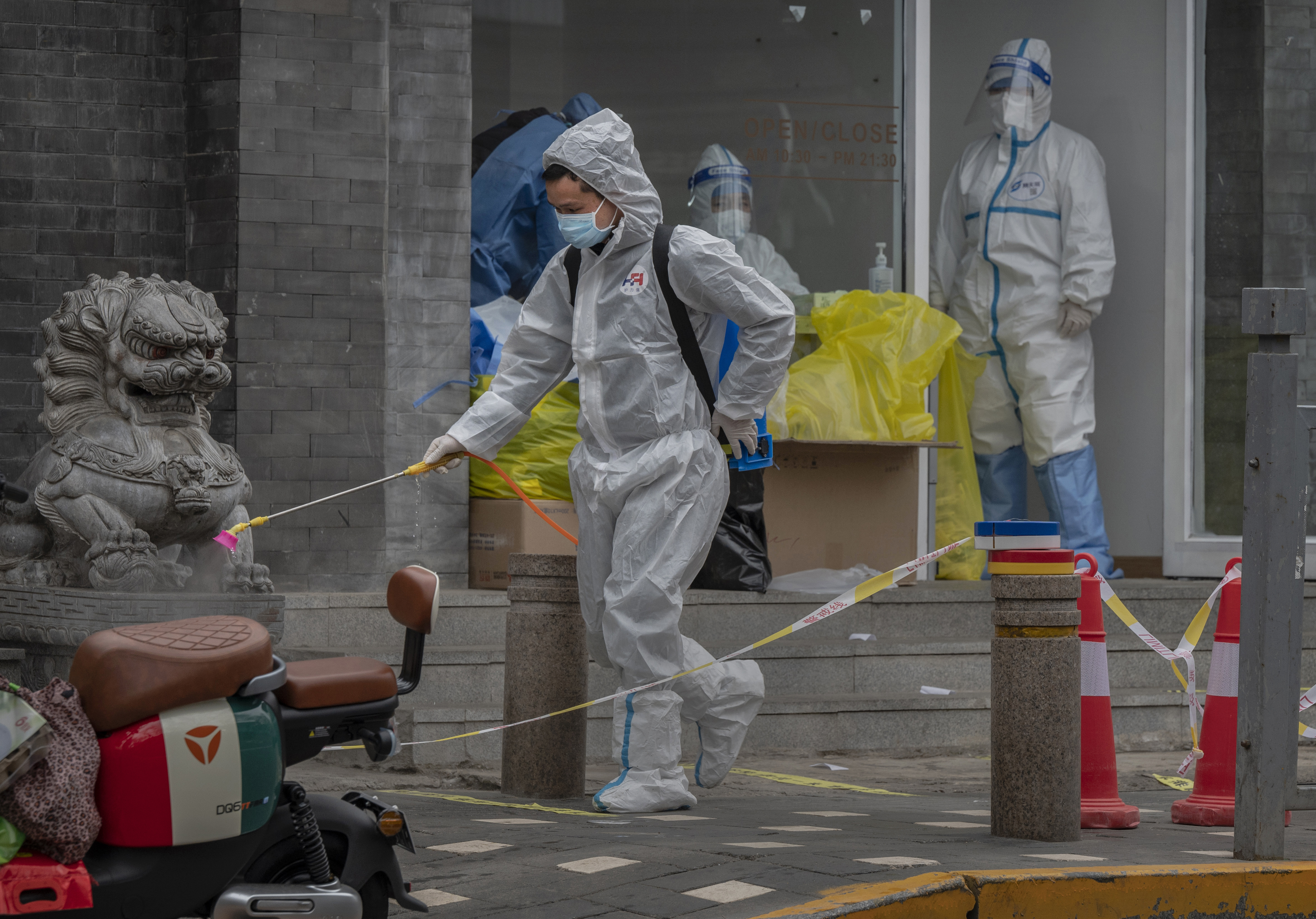 BEIJING, CHINA - MARCH 22: A health worker wears a protective suit as he disinfects the area near a nucleic acid testing site to detect COVID-19 in the street on March 22, 2022 in Beijing, China. China has stepped up efforts to control a recent surge in coronavirus cases across the country, locking down the entire province of Jilin and the city of Shenyang and putting others like Shenzhen and Shanghai under restrictions. Local authorities across the country are mass testing as China tries to ma