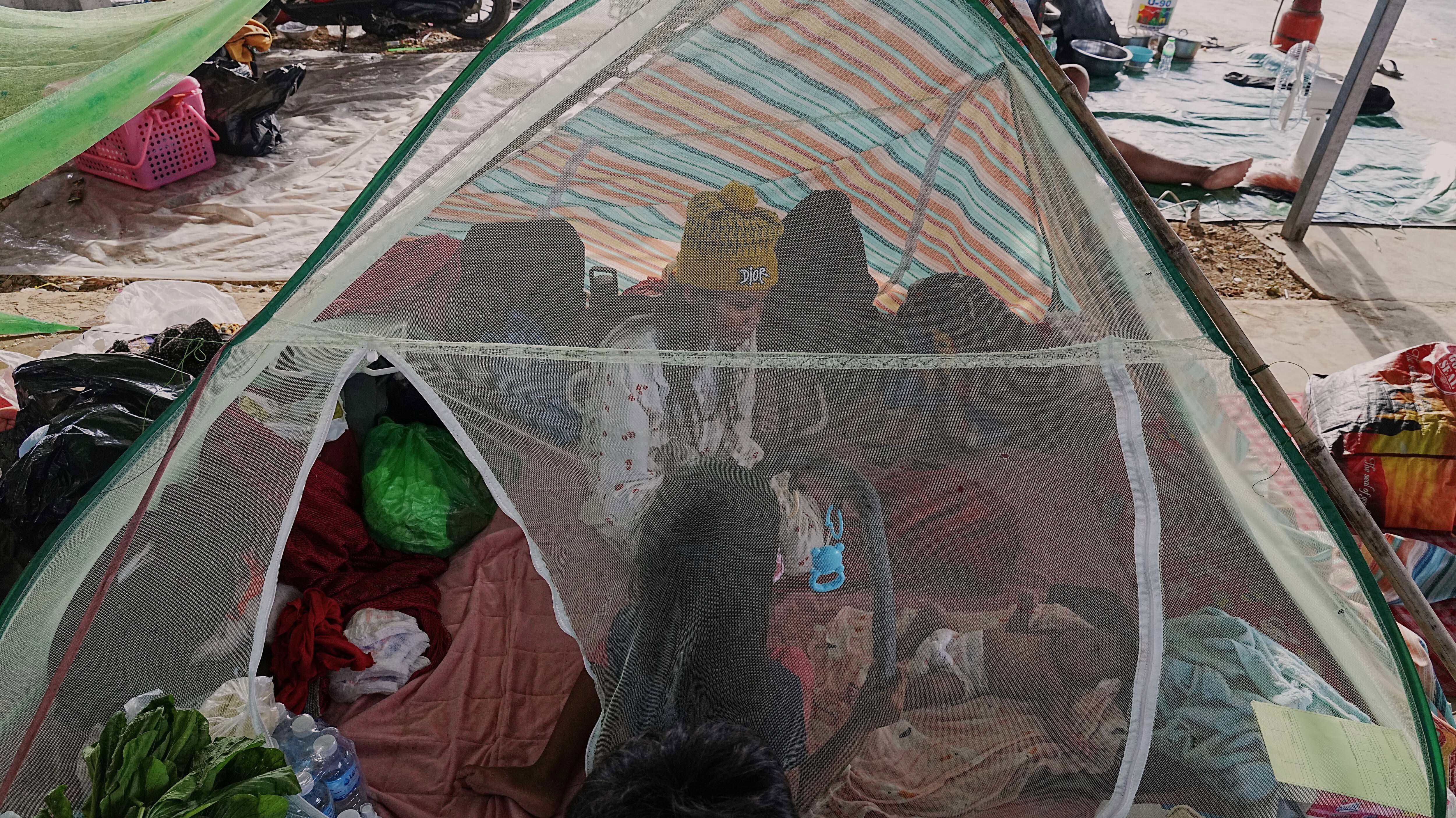 An evacuee woman sits in a mosquito net as she takes refuge in Banteay Menchey provincial town, Cambodia 