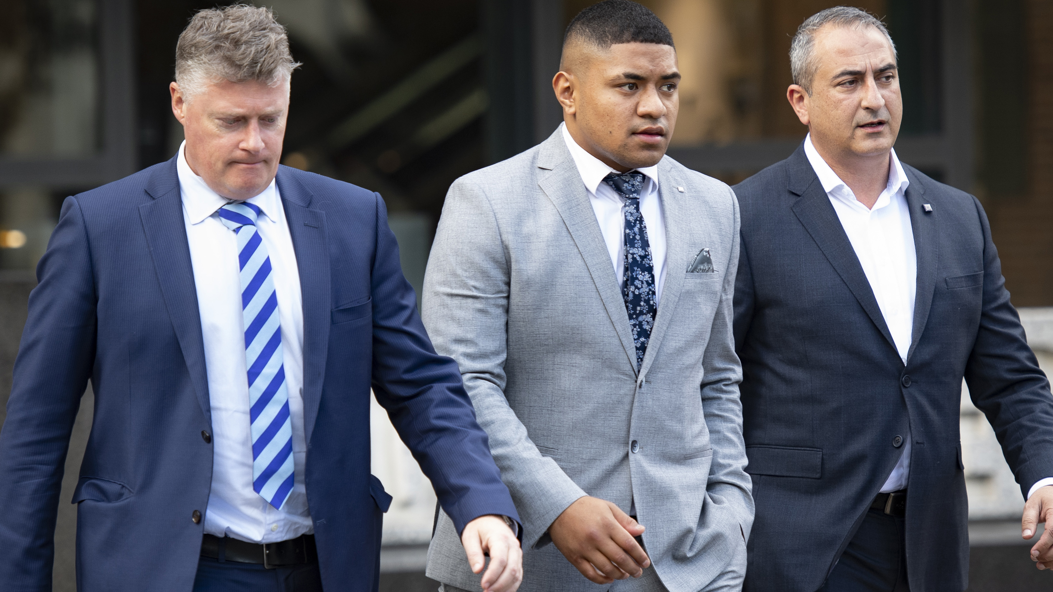 NRL Manly player Manase Fainu, centre, departs Parramatta Courthouse during a lunch break.