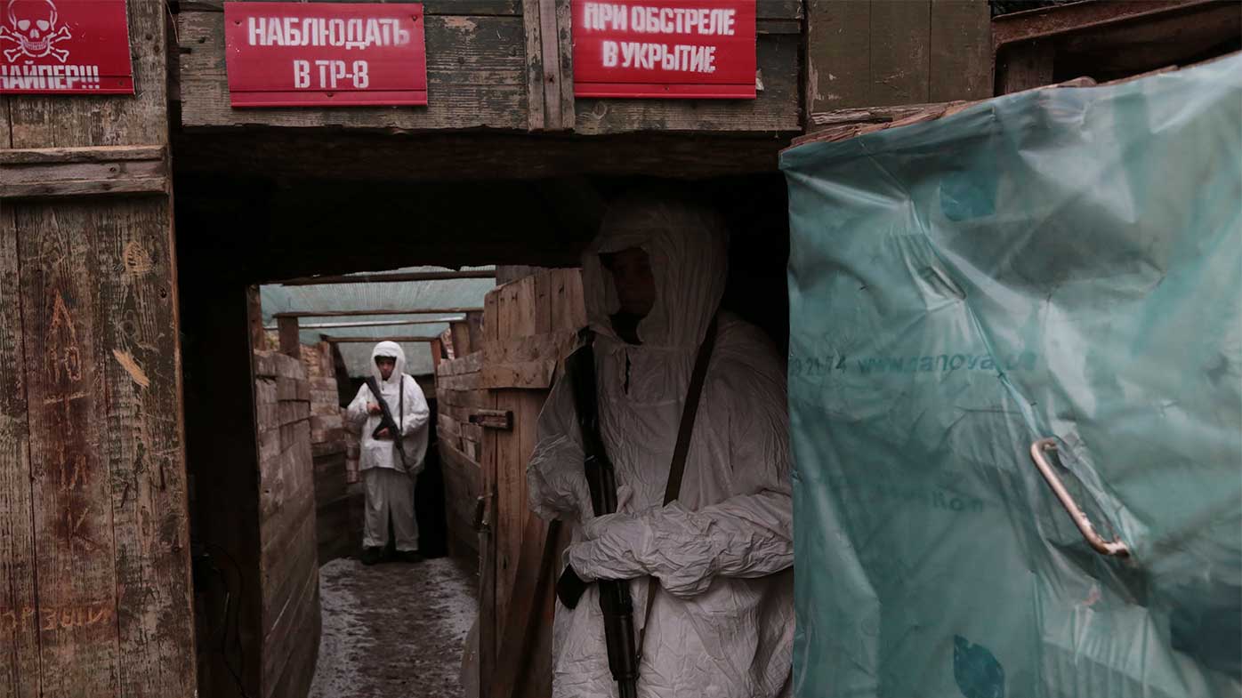 Soldiers in Ukraine stand guard in a trench in disputed territory.