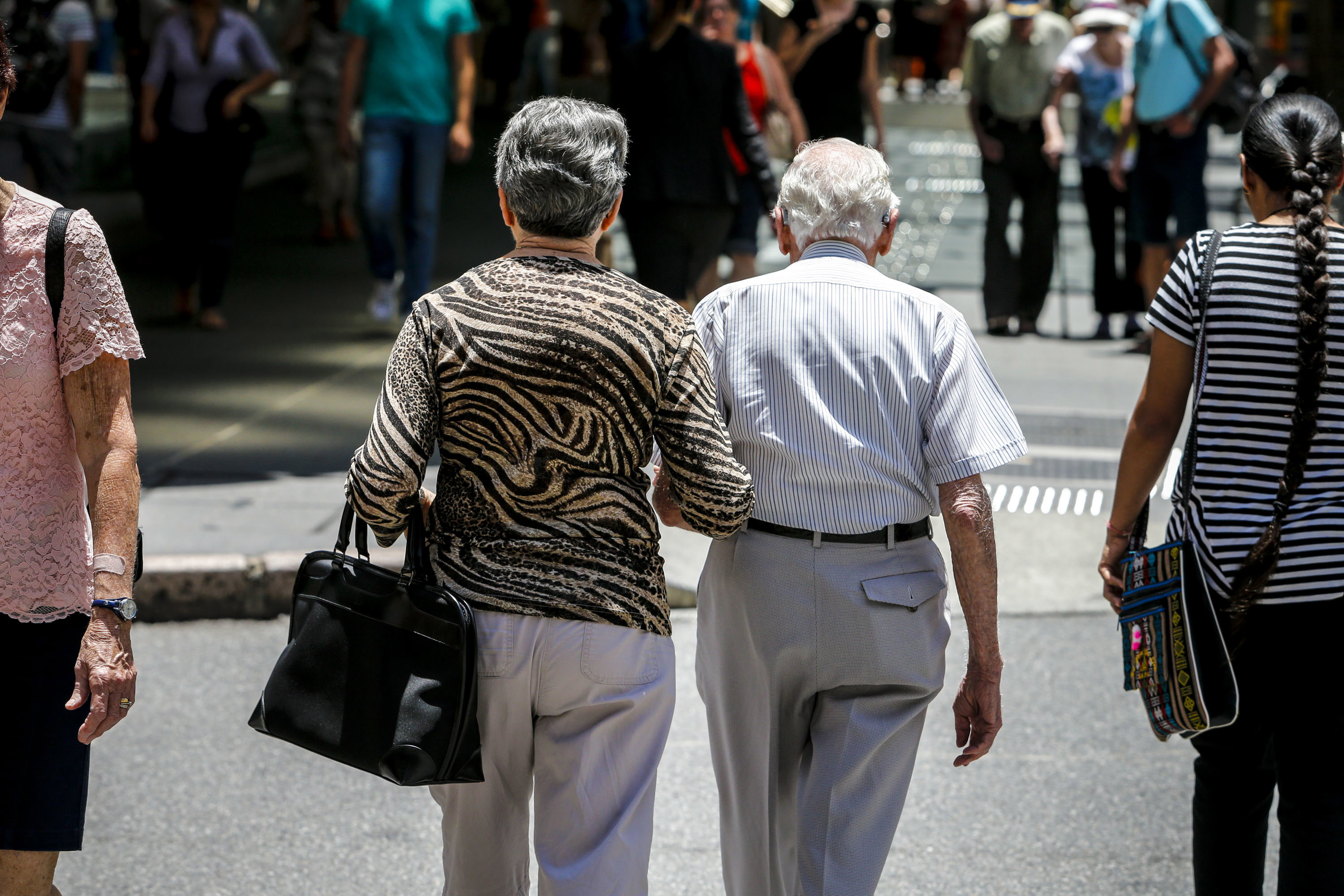 An elderly couple walks down the street in Brisbane.
