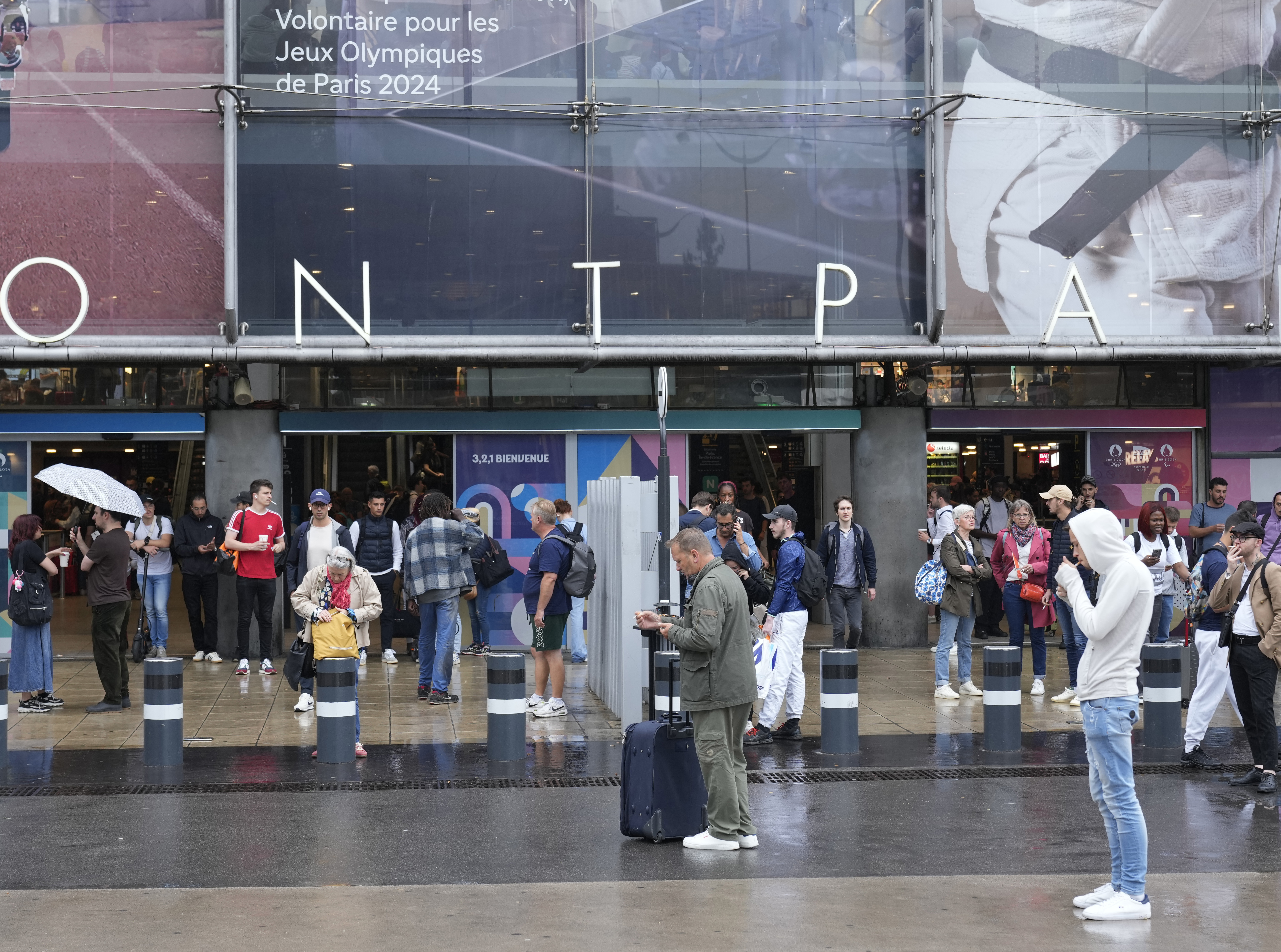 Travellers wait outside the Gare de Montparnasse train station, at the 2024 Summer Olympics, Friday, July 26, 2024, in Paris, France.