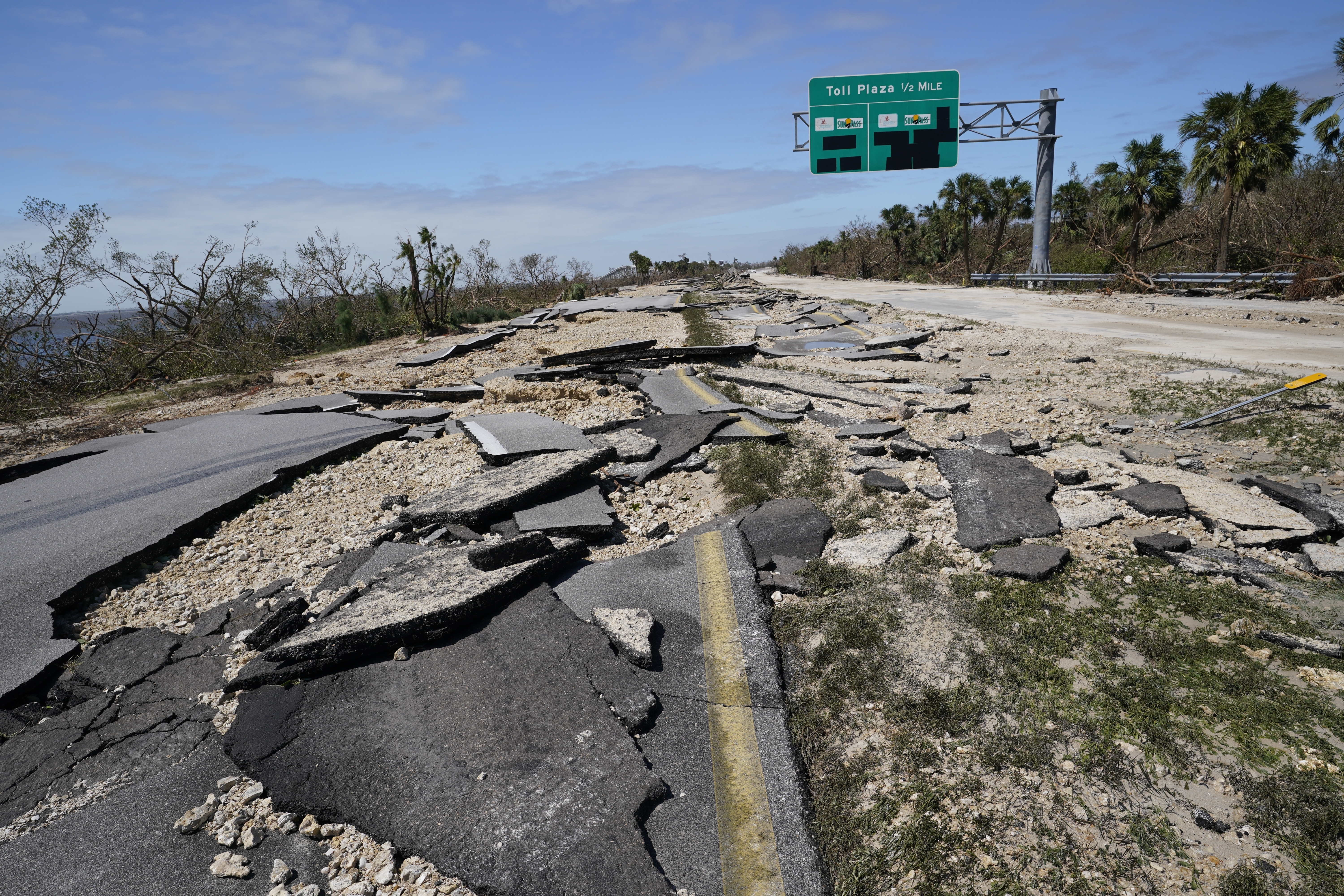 Broken pavement lies flat leading to the Sanibel Island causeway in the aftermath of Hurricane Ian, Thursday, Sept. 29, 2022, in Fort Myers, Fla. (AP Photo/Steve Helber)