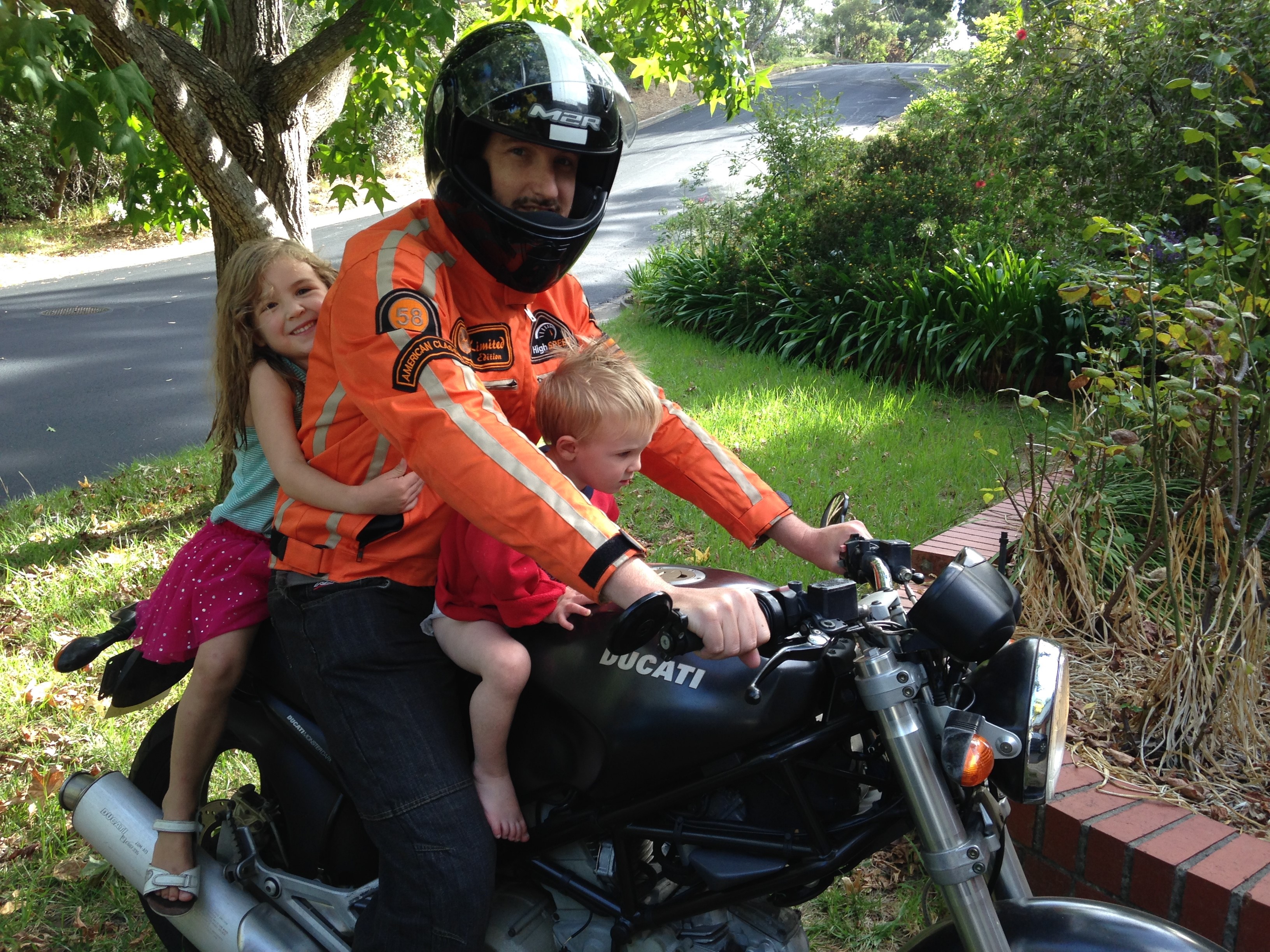 Leigh on his motorbike with his children, Zoe and Finn.