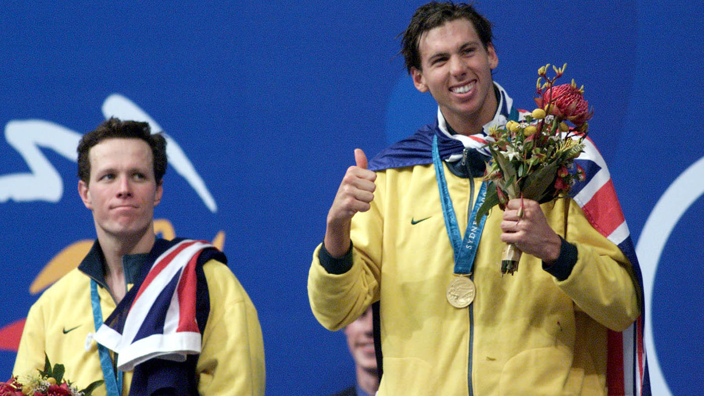 An ecstatic Grant Hackett celebrates gold as a glum Kieren Perkins watches on.