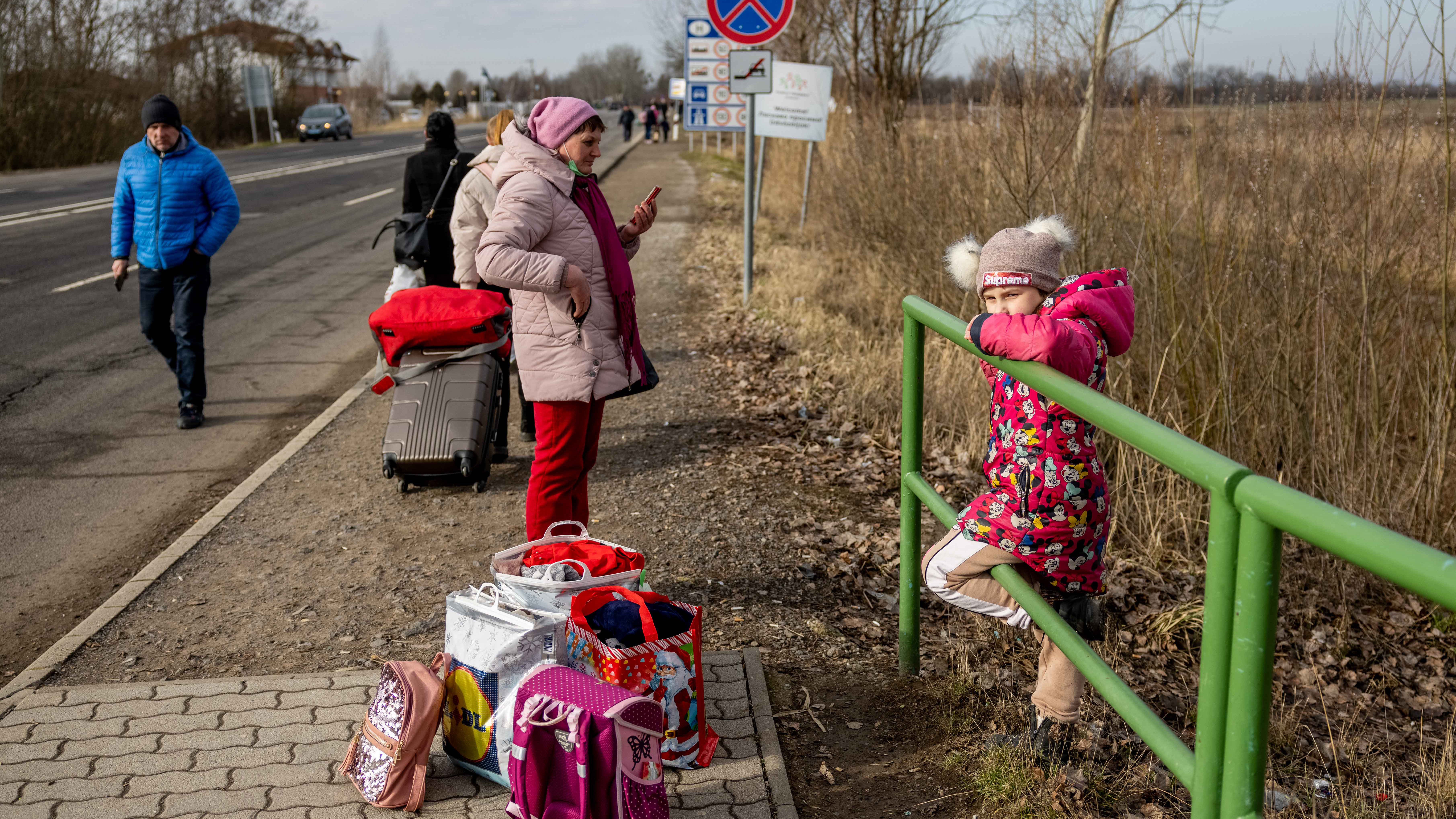 People wait with their belongings at the Astely-Beregsurany border crossing in Beregsurany, Hungary. 