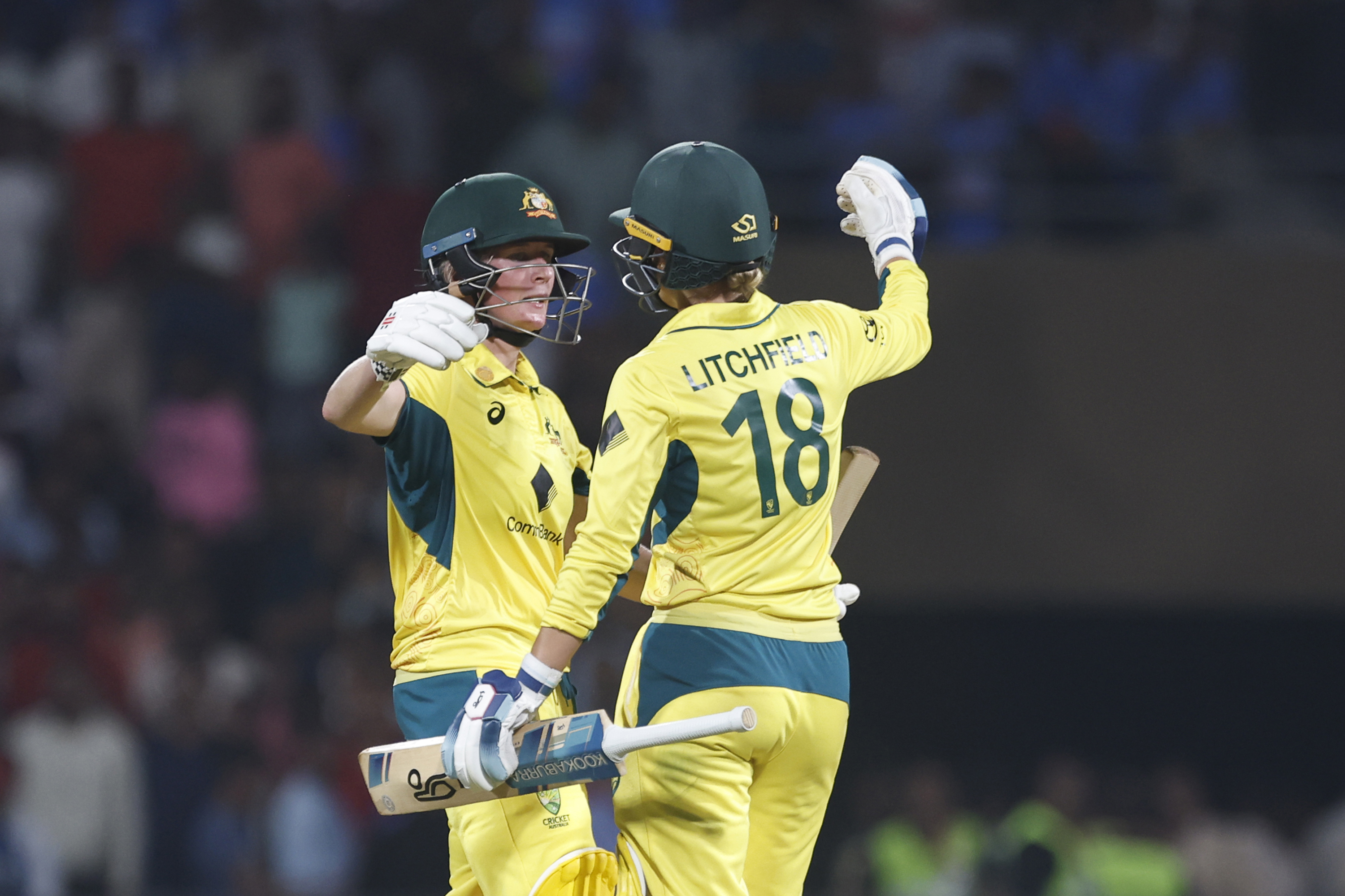 Phoebe Litchfield and Beth Mooney of Australia celebrate their team's win.