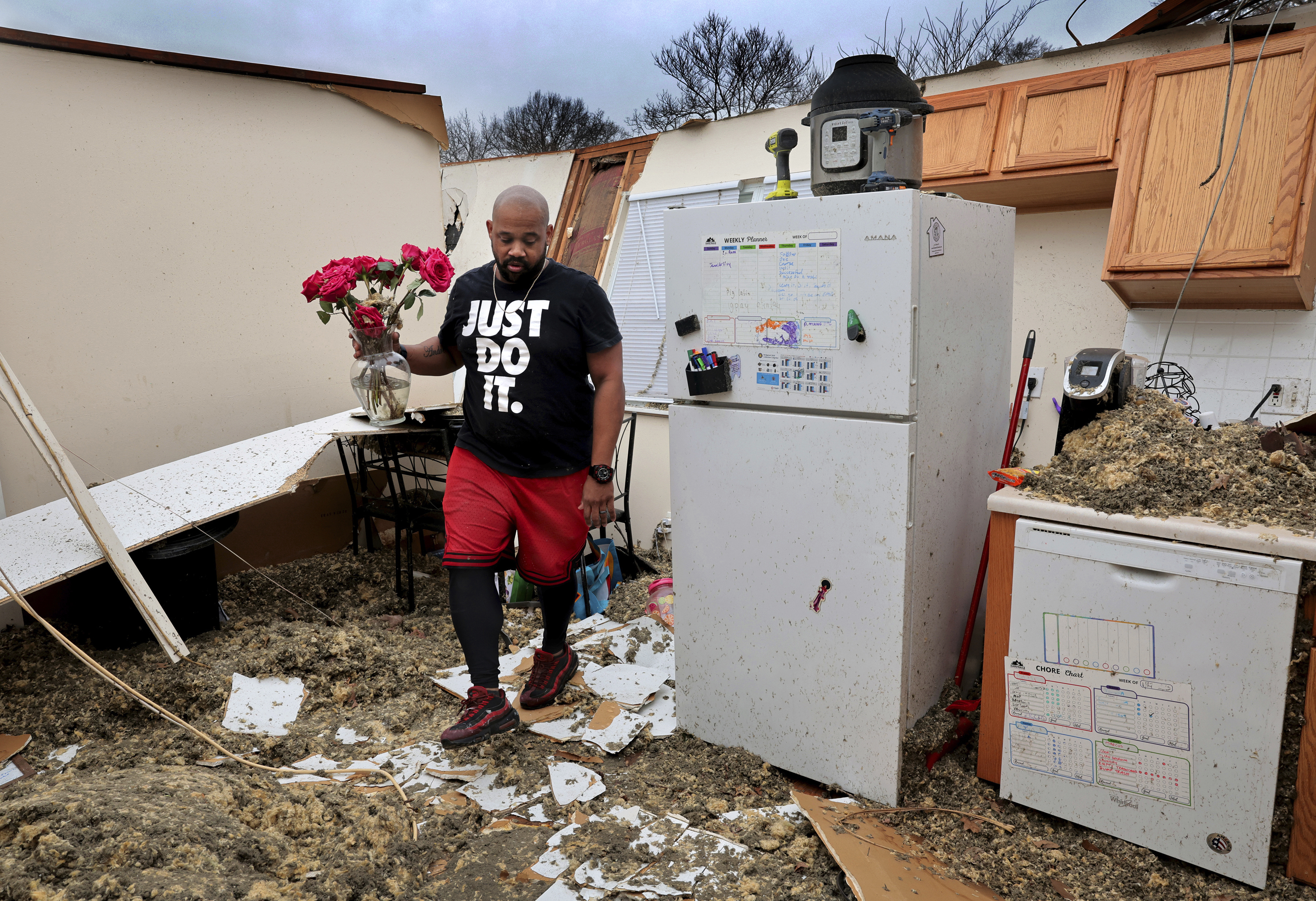 Marcus Cole finds his wife's, Tamara, undamaged roses on a kitchen table while he salvaging belongings