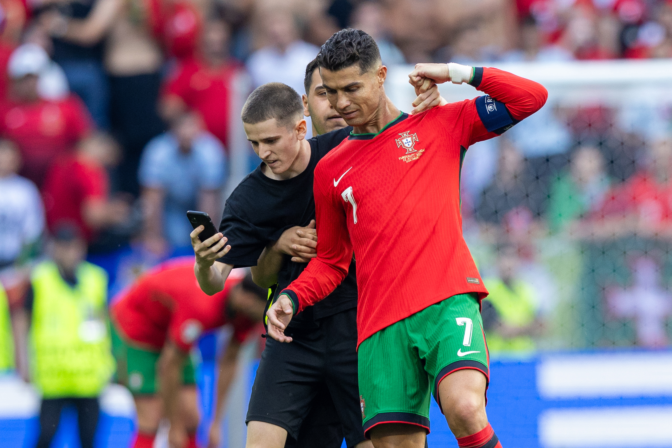 A pitch invader takes a selfie photograph with Portugal forward Cristiano Ronaldo during the UEFA Euro 2024 Group F match between Turkiye v Portugal, at the  BVB Stadion Dortmund in Dortmund, Germany, on June 22, 2024. (Photo by Andrzej Iwanczuk/NurPhoto via Getty Images)