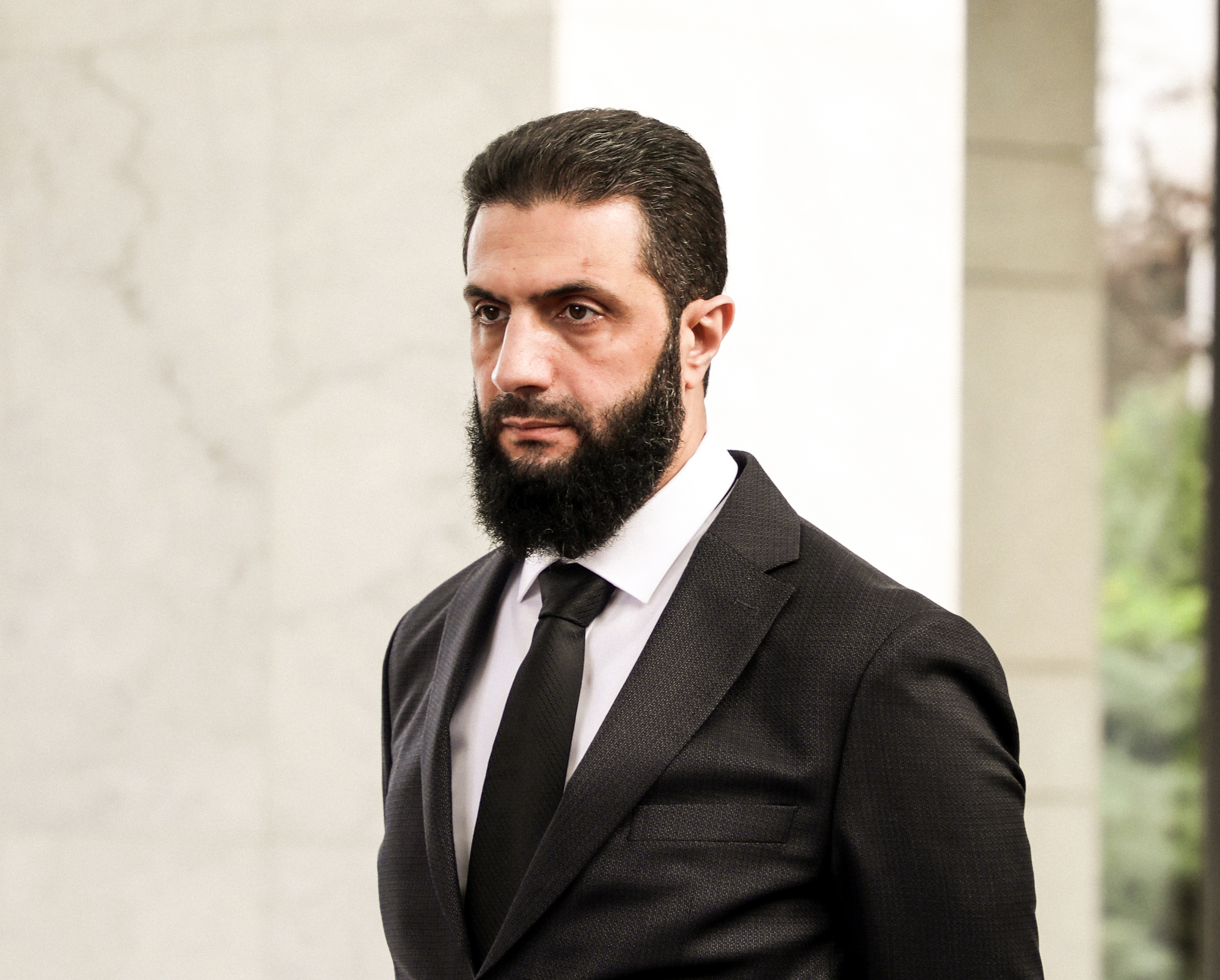 DAMASCUS, SYRIA - DECEMBER 30: The leader of the new Syrian administration, Ahmed al-Sharaa waits to greet Ukrainian Foreign Minister Andrii Sybiha (not in picture) ahead of a meeting between the Syrian leadership and a Ukrainian delegation to help strengthen ties between the two countries on December 30, 2024 in Damascus, Syria. Syria is transitioning after the fall of the Baath regime and the Assad family's rule, with a temporary administration now in place in Damascus and Aleppo. (Photo by Al