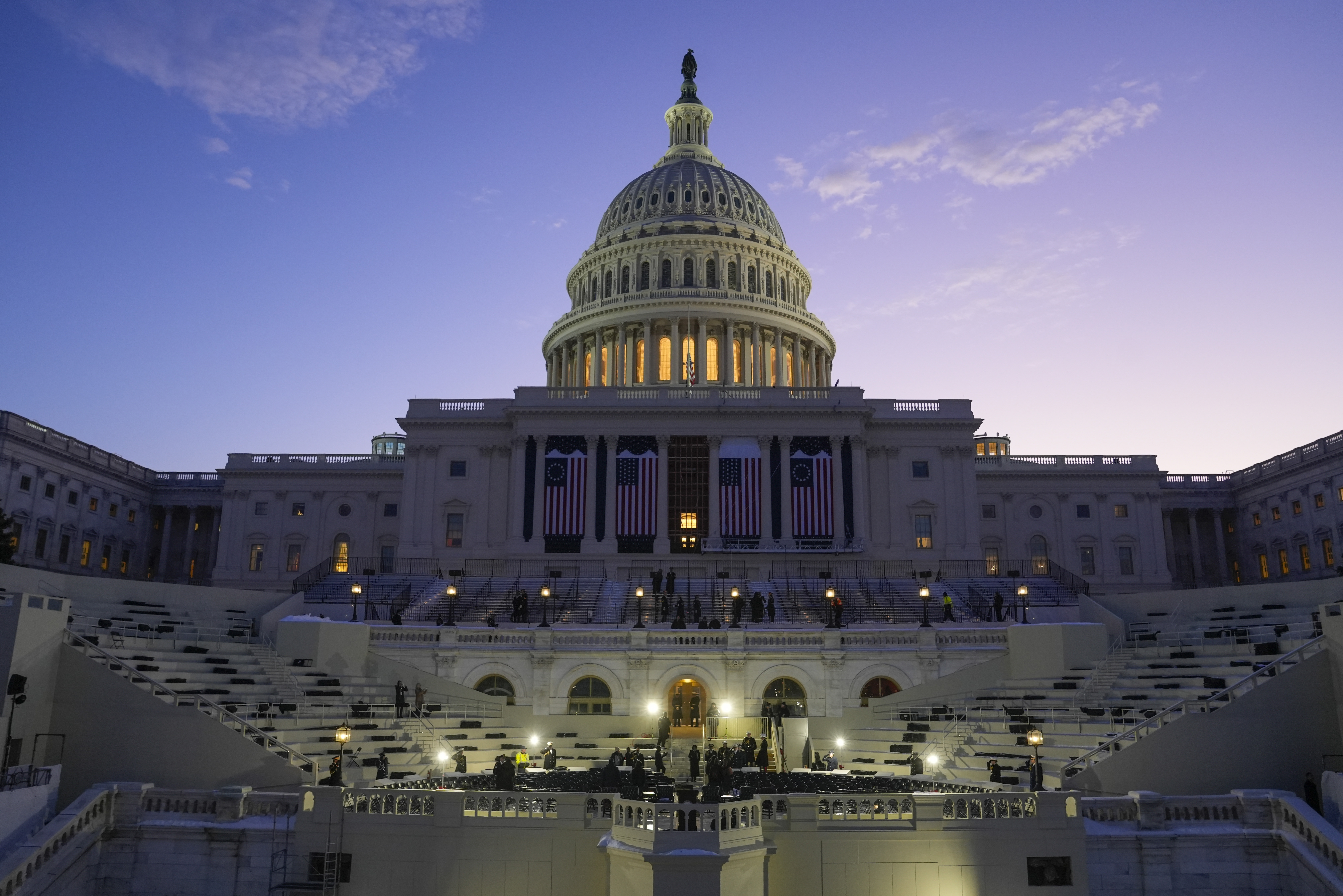 El sol sale detrás del Capitolio de Estados Unidos cuando comienza un ensayo de inauguración 