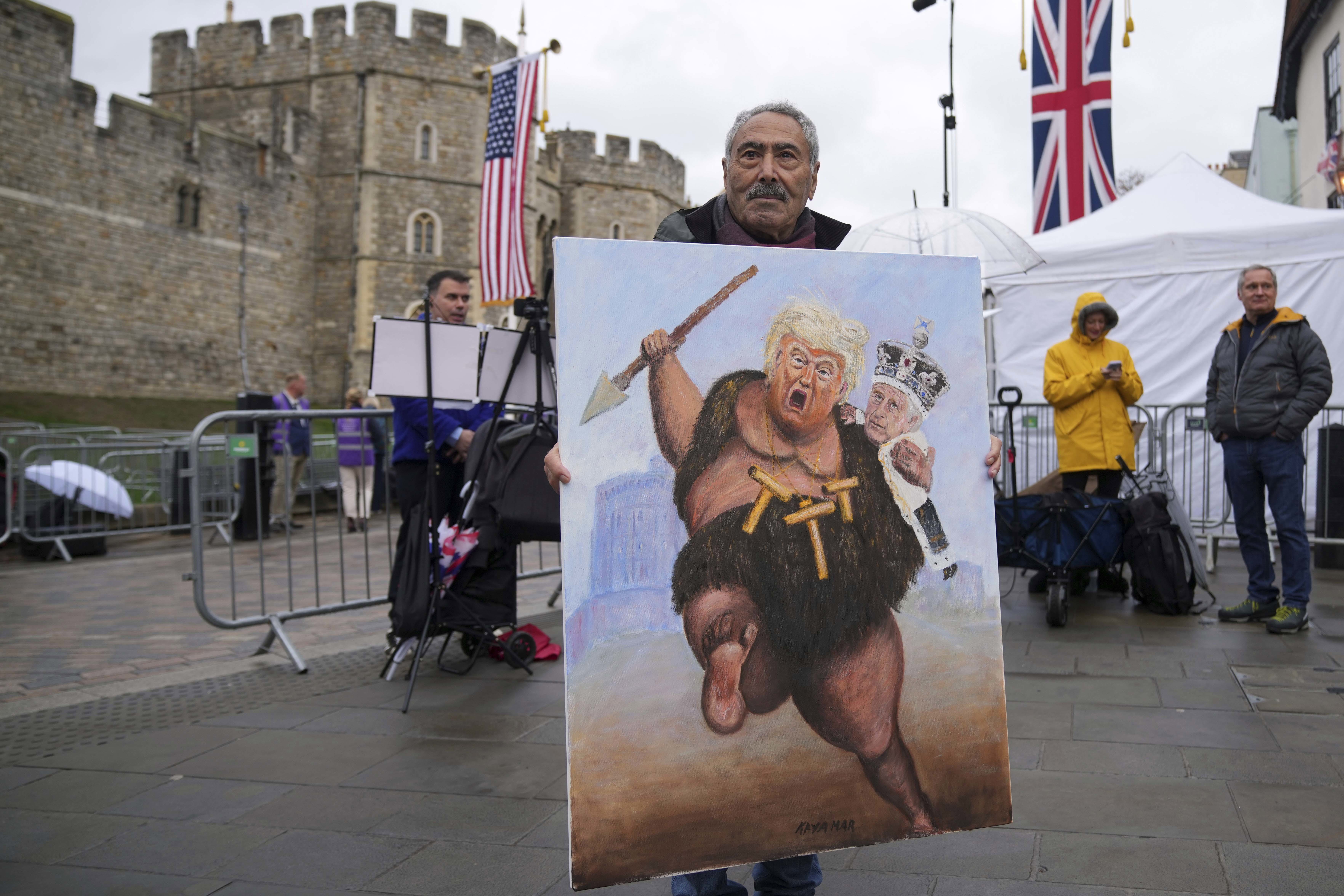 Artist Kaya Mar poses with his latest painting besides Windsor Castle ahead of the arrival of President Donald Trump in Windsor.