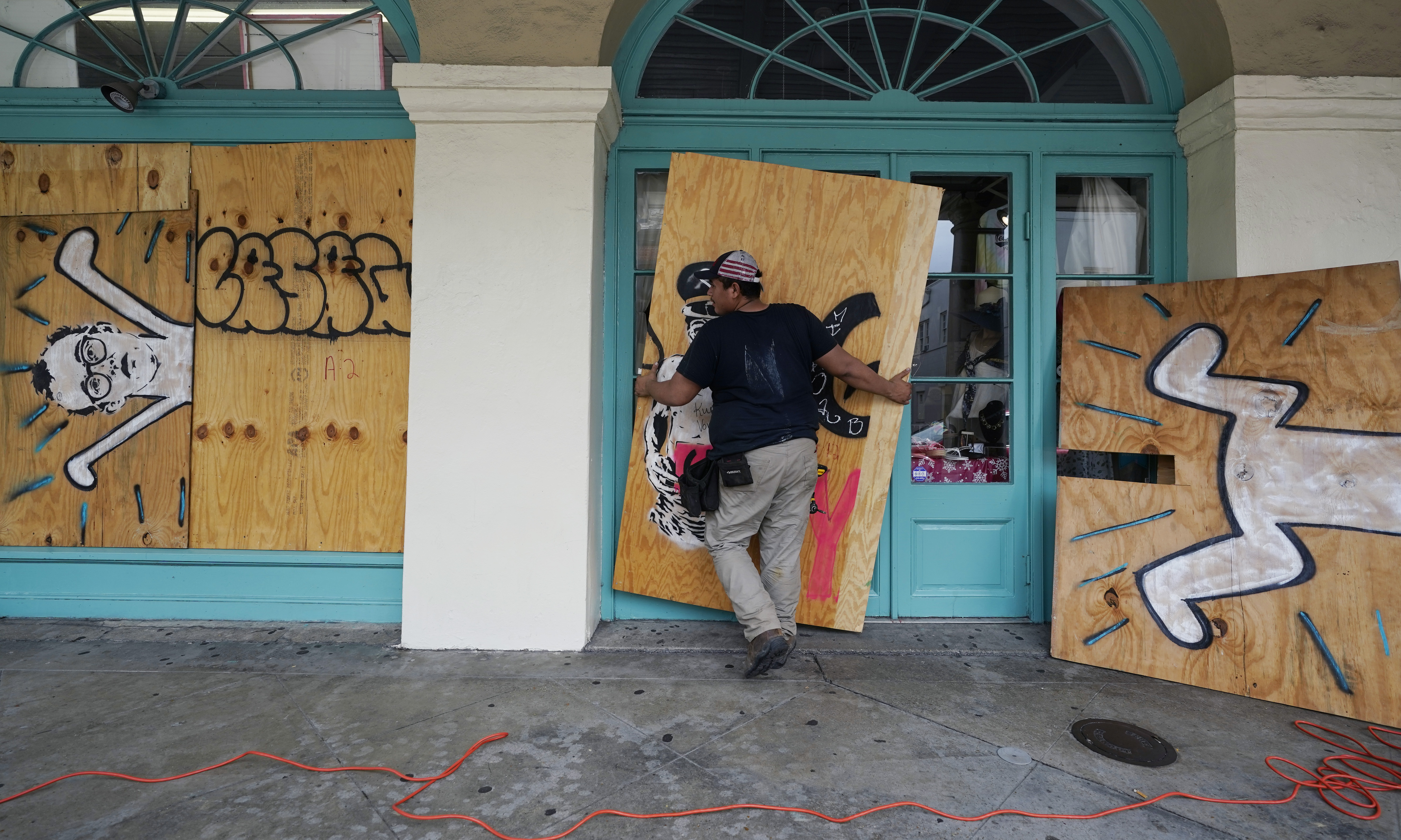 In preparation of Hurricane Ida, a workers attach protective plywood to windows and doors of a business in the French Quarter in New Orleans, Saturday, August 28, 2021. (AP Photo/Eric Gay)