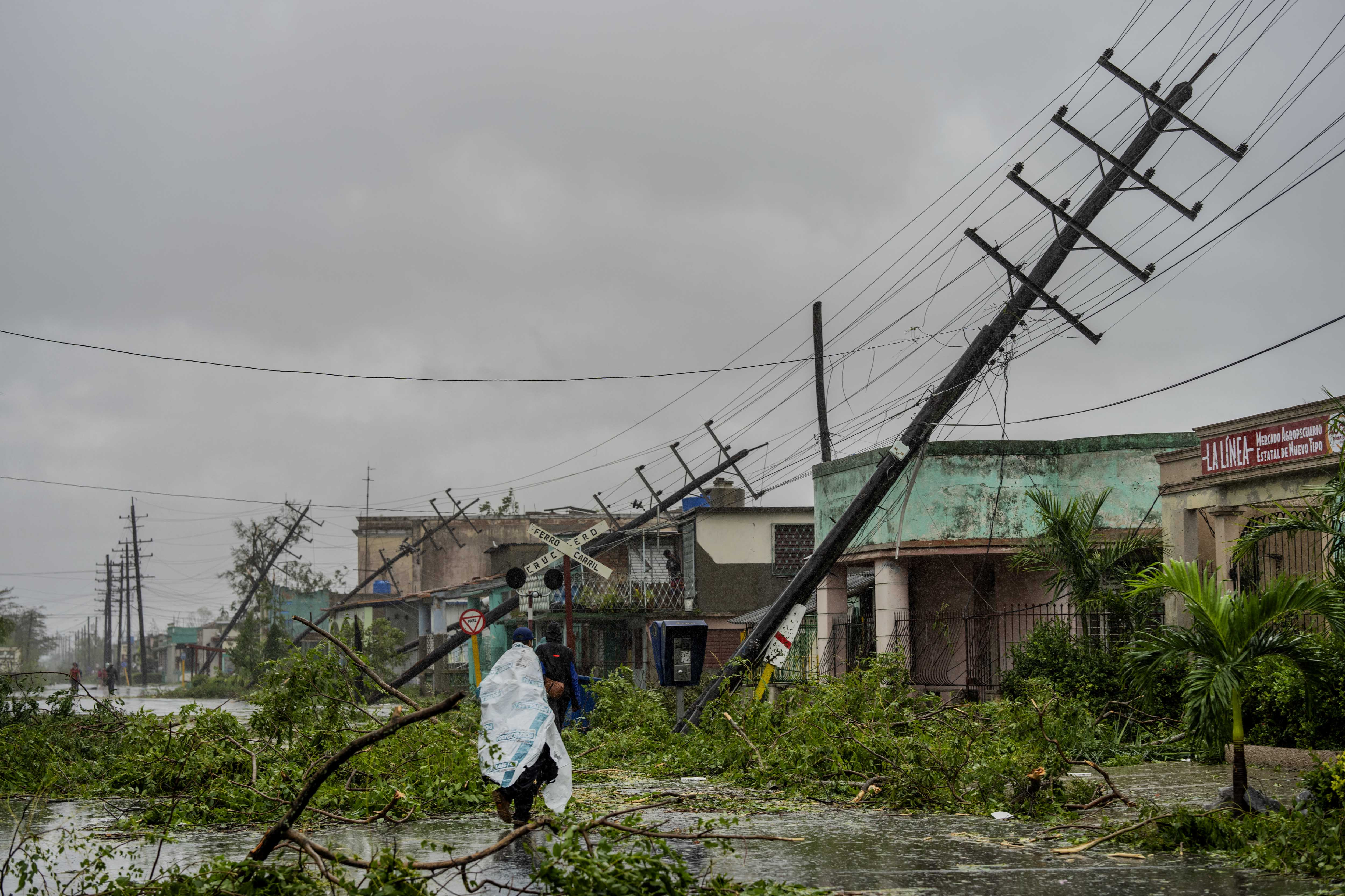 Postes de servicios públicos caídos y ramas caídas bordean una calle después de que el huracán Ian azotara Pinar del Río, Cuba, el martes 27 de septiembre de 2022. 