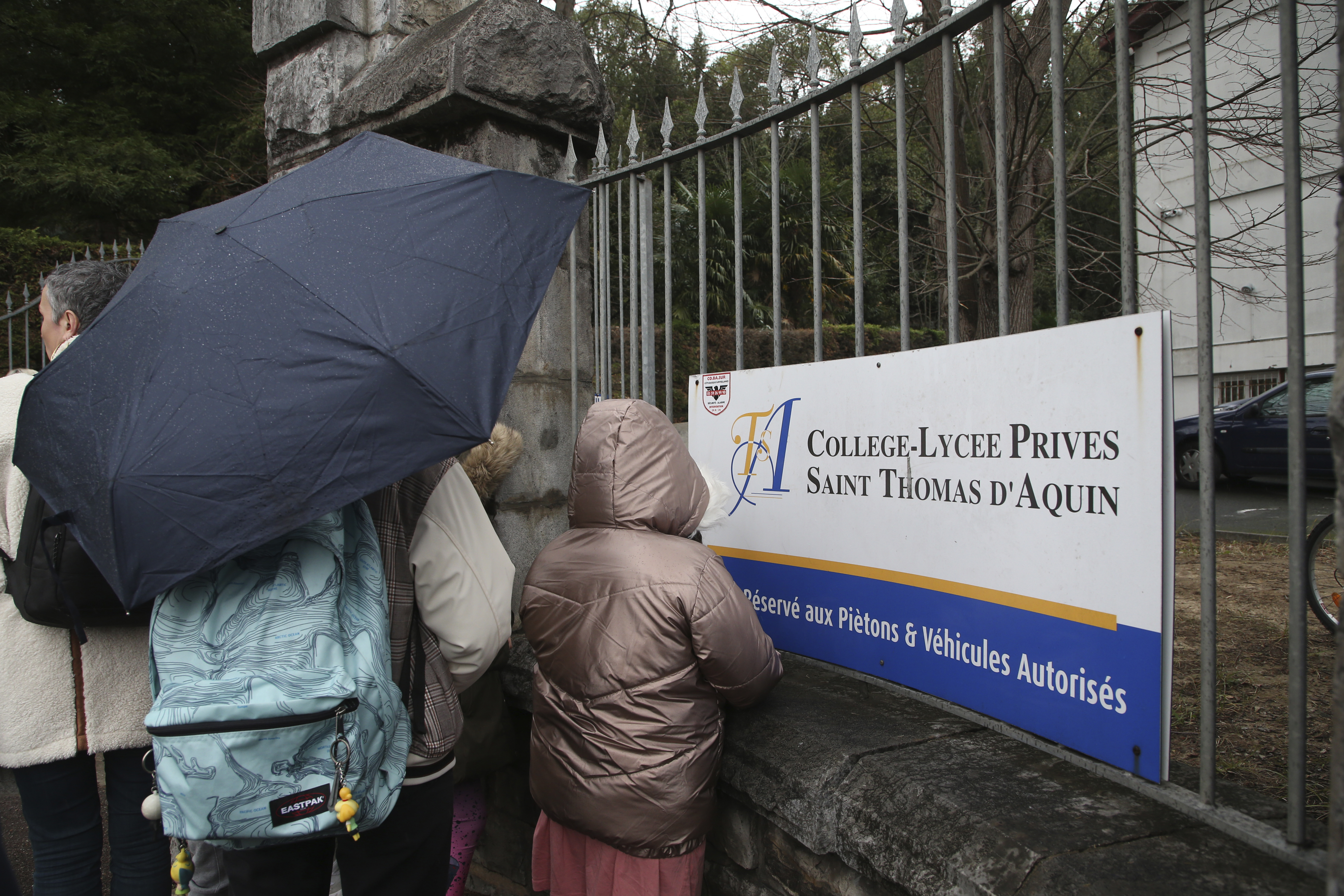A child looks through the entrance of a private Catholic school after a teacher has been stabbed to death by a high school student, Wednesday, Feb. 22, 2023 in Saint-Jean-de-Luz, southwestern France. 