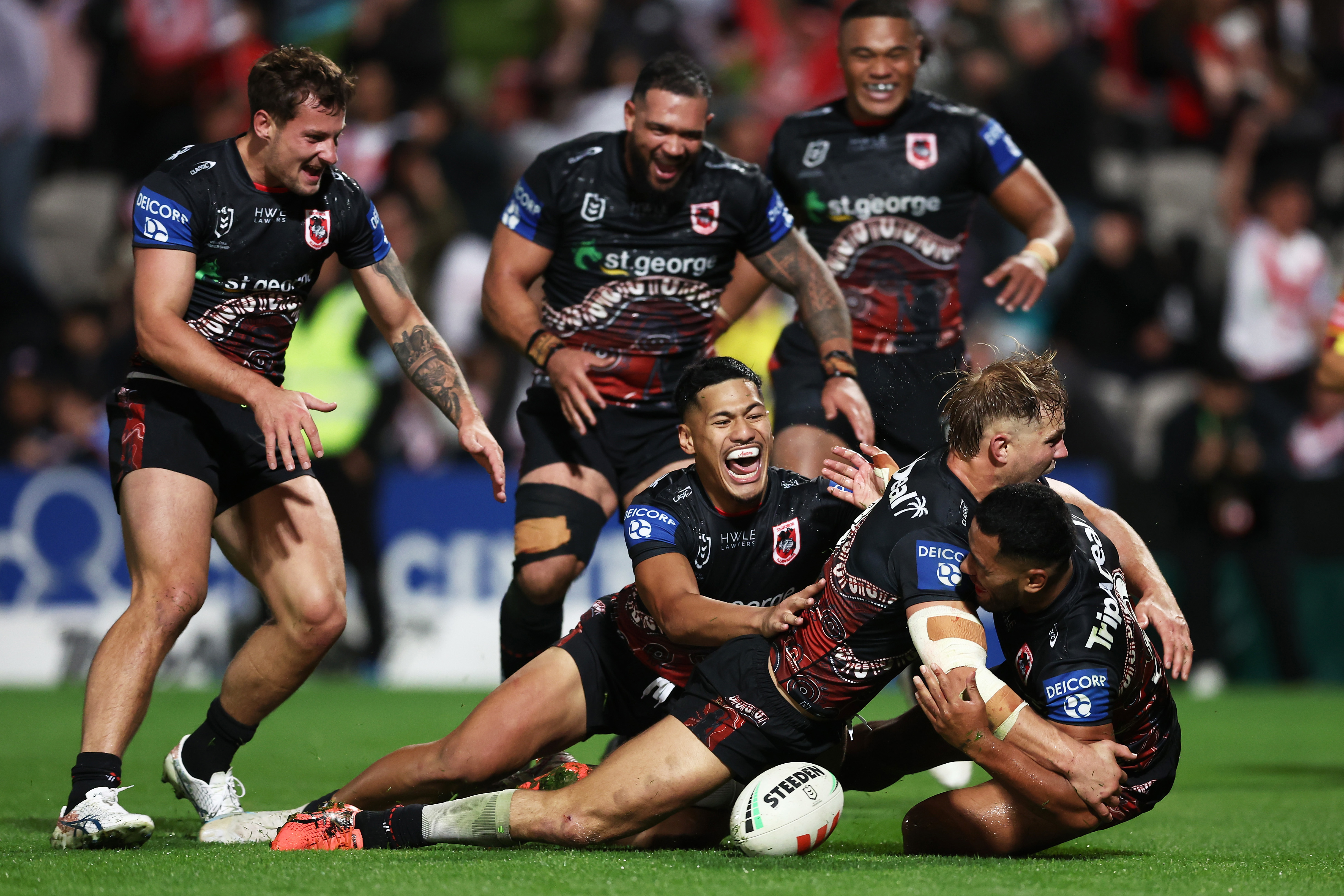 Mathew Feagai celebrates with his Dragons teammates after scoring the match-winning try against the Roosters.