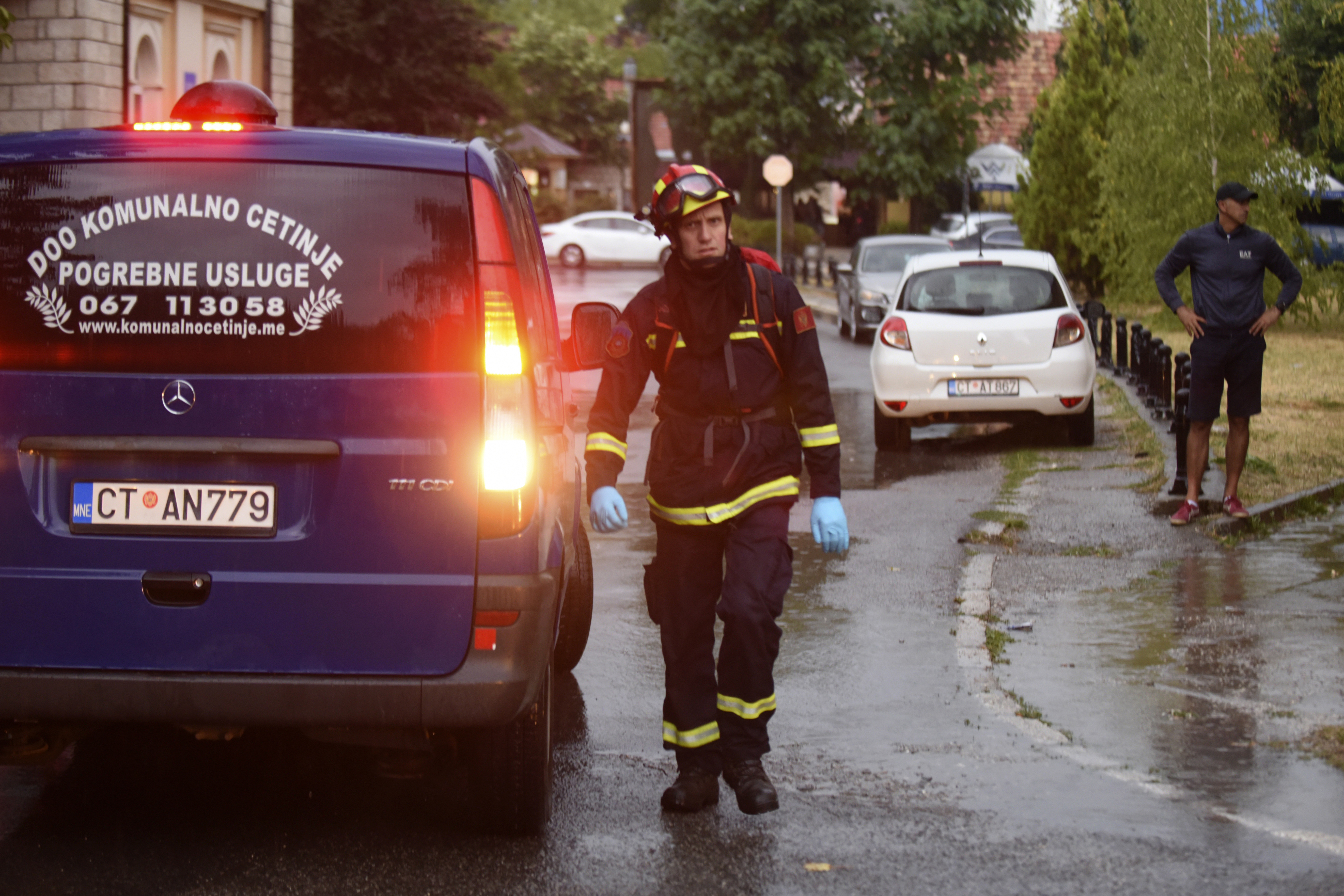 A firefighter walks by a hearse on the site of the attack in Cetinje, 36 kilometres west of Podgorica, Montenegro, Friday, Aug. 12, 2022. A man in Montenegro went on a shooting rampage after a family dispute, killing 11 people on the streets of a city before being shot dead in a gun battle with police. (AP Photo/Risto Bozovic)