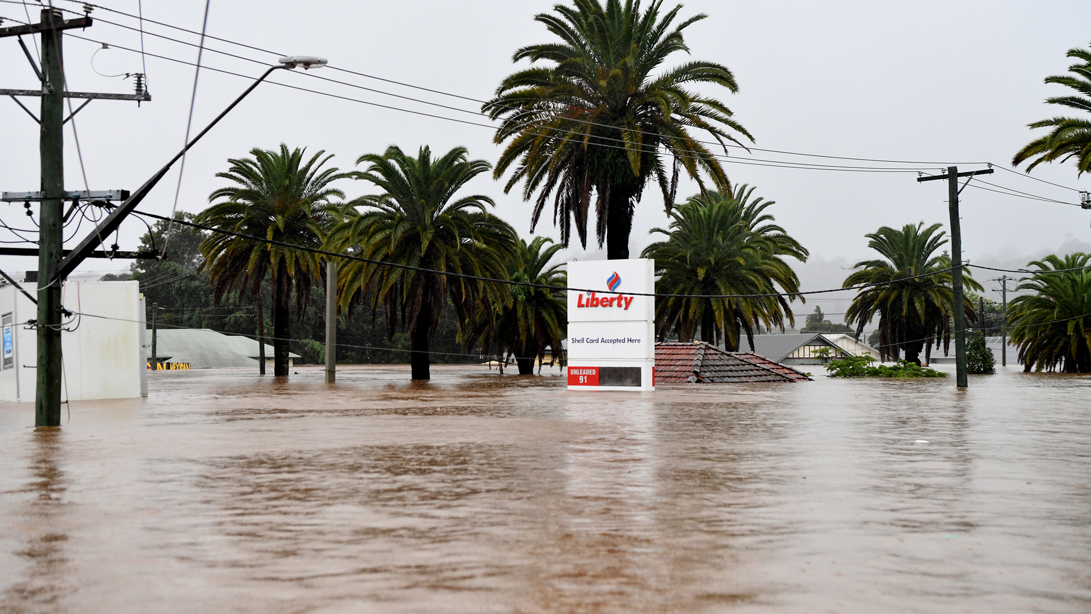 A petrol station sign shows the depth of the water.