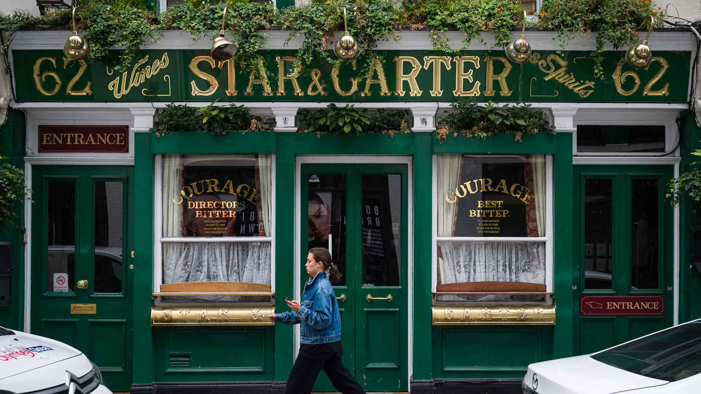 A woman walks past a temporarily closed pub on June 19, 2020 in London, England.