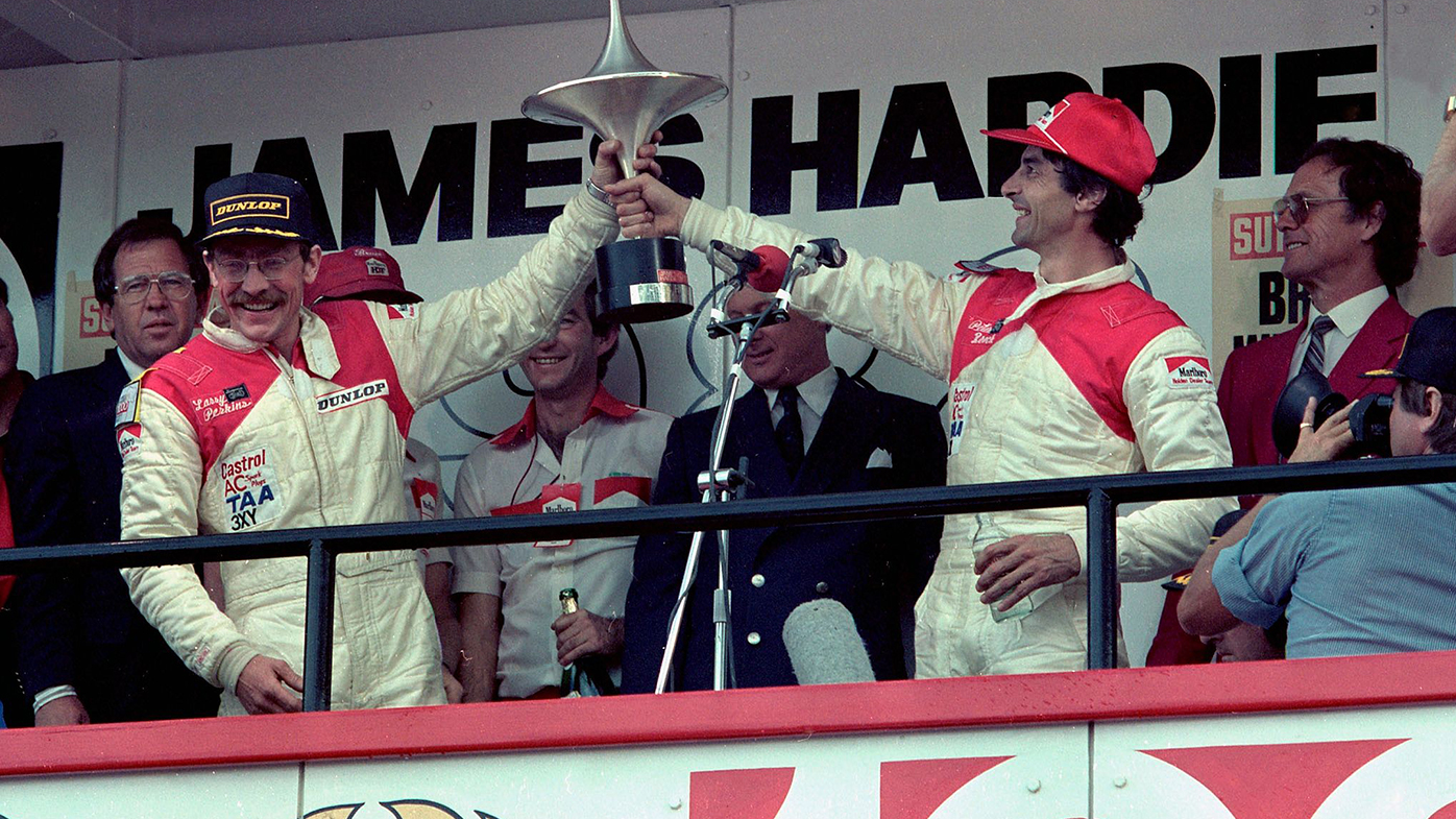 Larry Perkins (left) and Peter Brock on the podium after winning the 1982 Bathurst 1000.