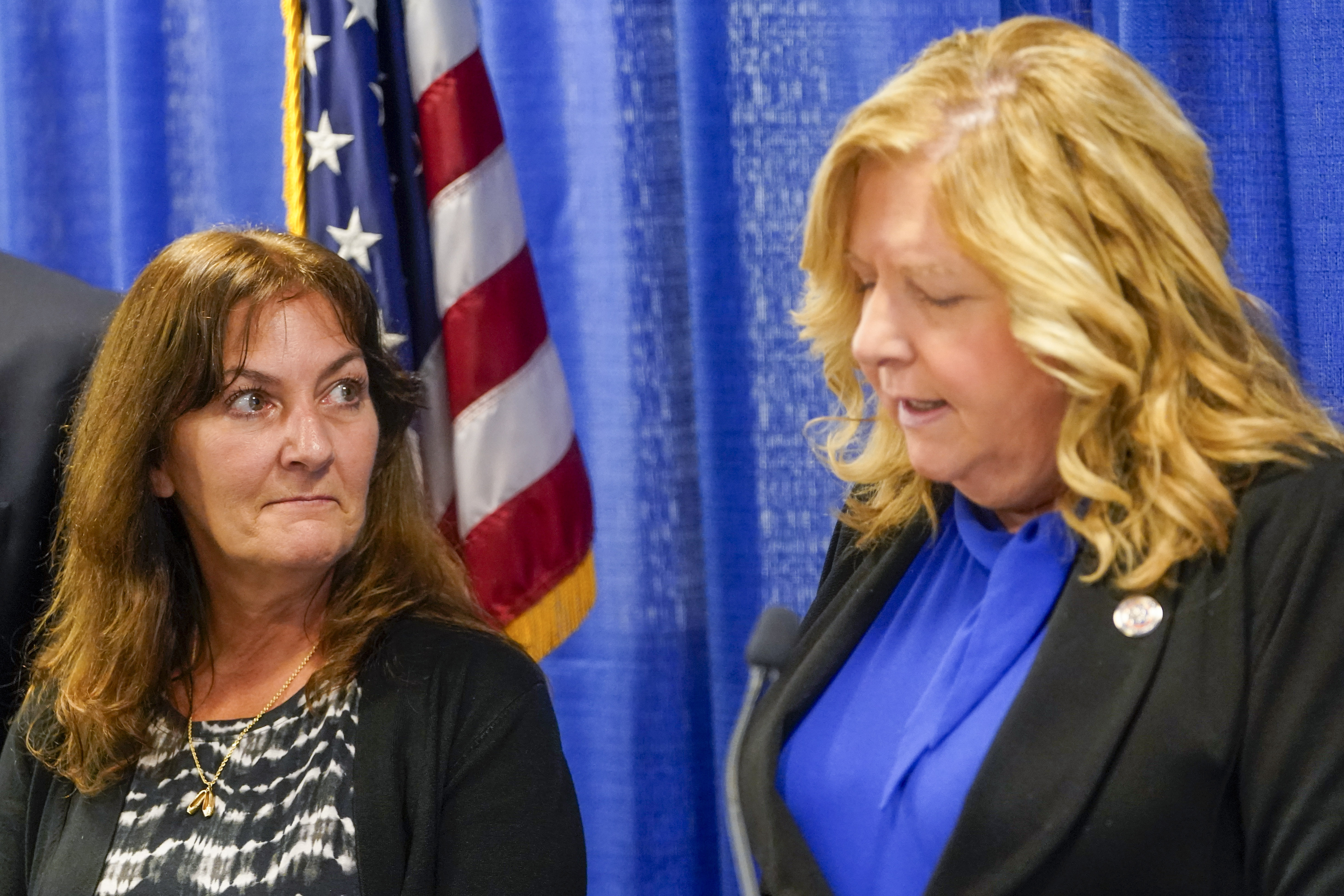 Darlene Altman, left, daughter of Diane Cusick, looks on as Nassau County District Attorney Anne Donnelly speaks during a news conference, Wednesday, June 22, 2022, in Mineola, N.Y. More than 50 years after a woman was found dead in her car at a mall on Long Island, authorities prosecutors are expected to announce that DNA evidence has linked the slaying to Richard Cottingham, a serial killer who has been connected to 11 murders in New York and New Jersey between 1965 and 1980. (AP Photo/Mary Al