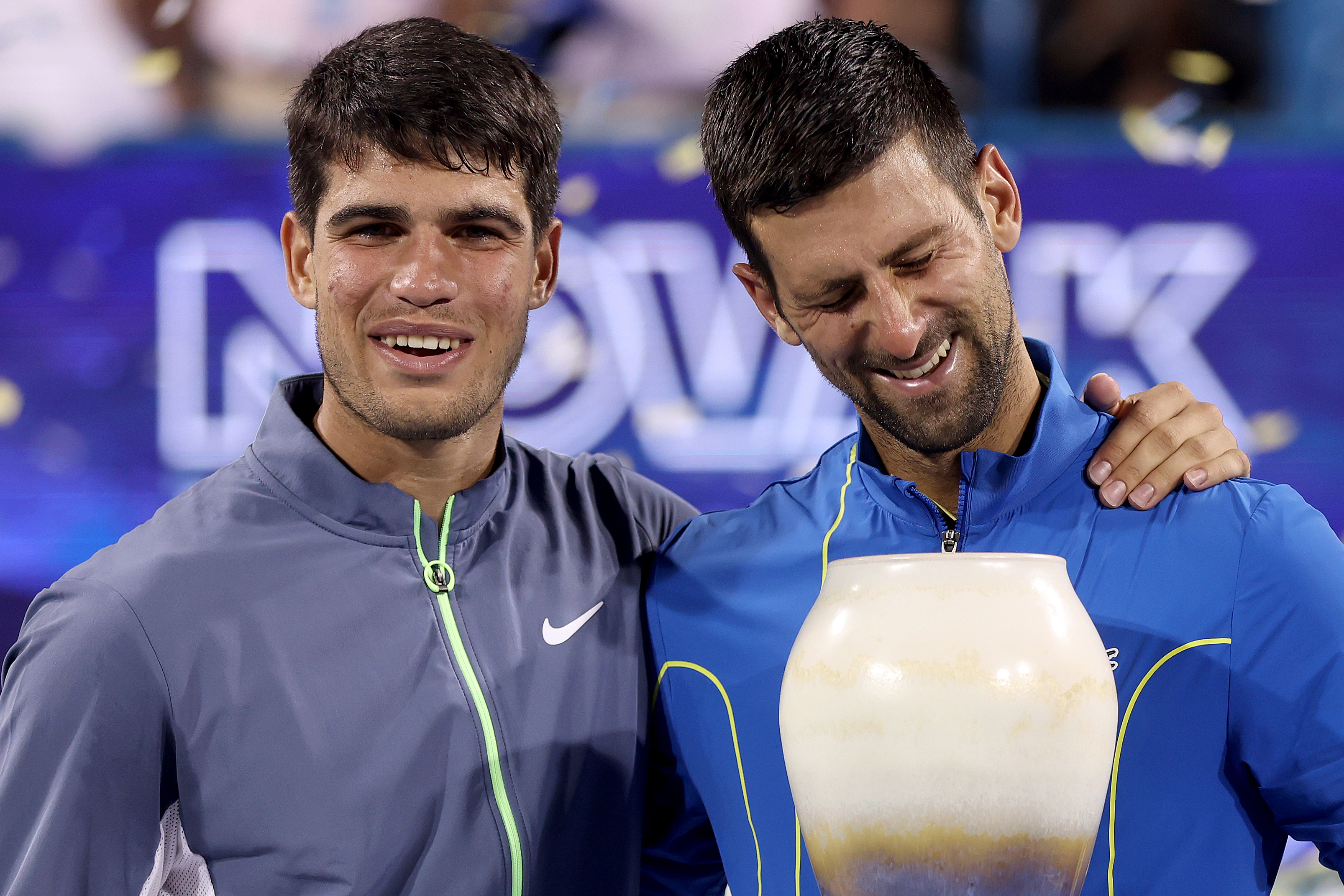 Carlos Alcaraz of Spain and Novak Djokovic of Serbia pose with their trophies.