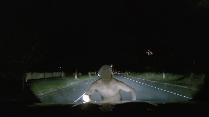 The man is seen leaping onto the bonnet of the car.