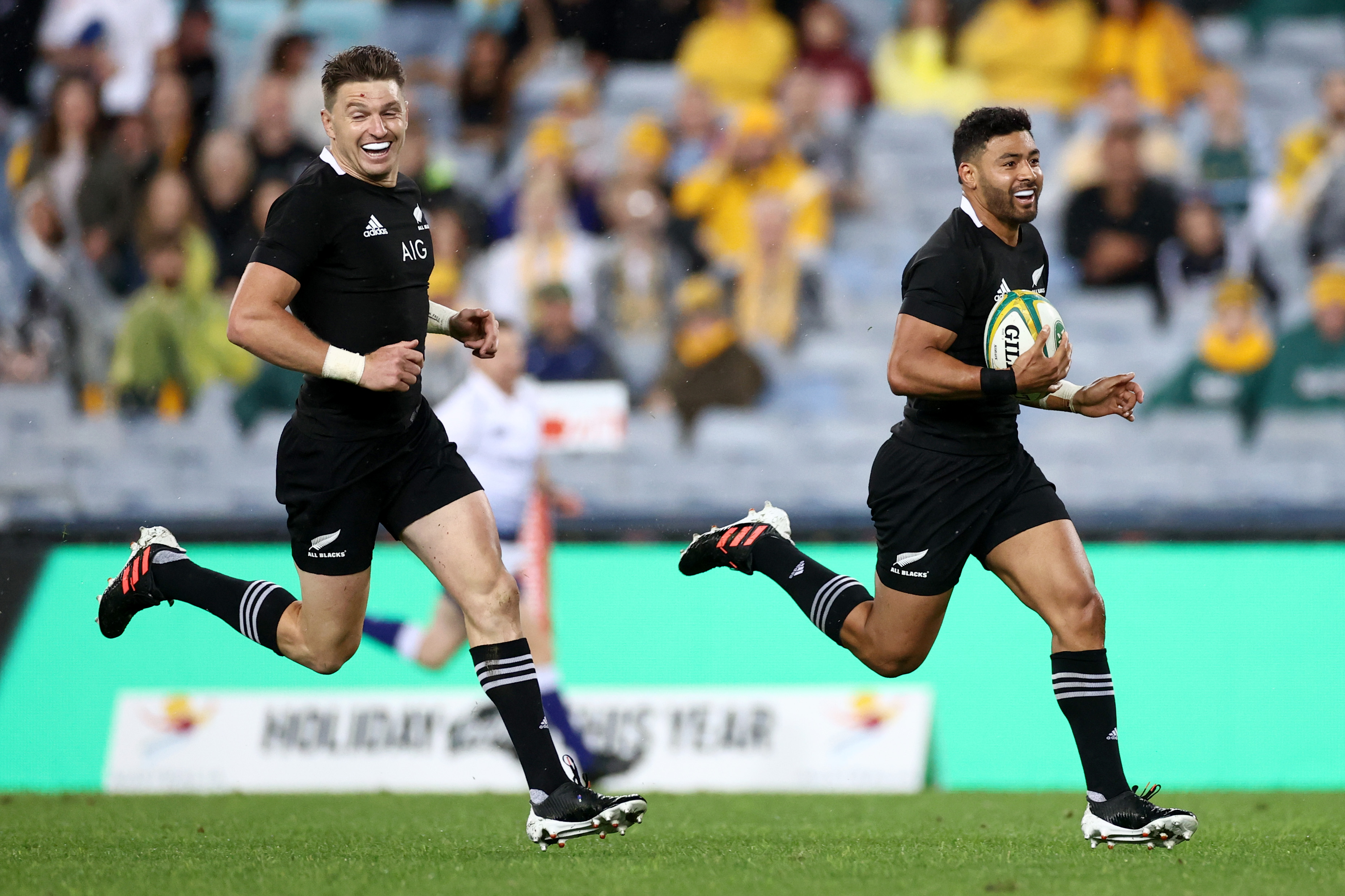 Beauden Barrett celebrates as Richie Mo'unga of the All Blacks runs in to score.