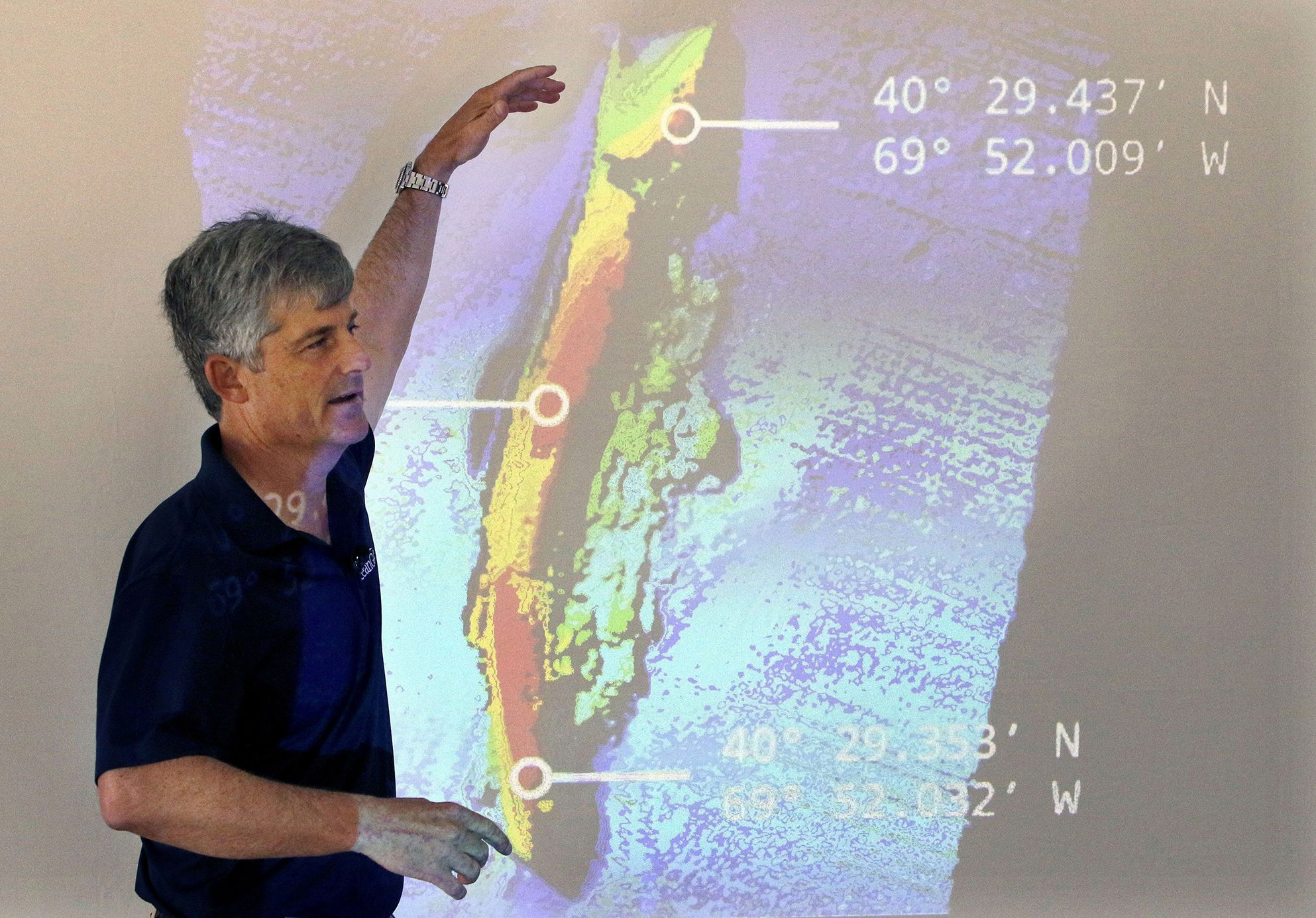 El director ejecutivo y cofundador de OceanGate, Stockton Rush, habla frente a una imagen proyectada de los restos del transatlántico SS Andrea Doria durante una presentación sobre sus hallazgos después de una exploración submarina, el 13 de junio de 2016, en Boston.