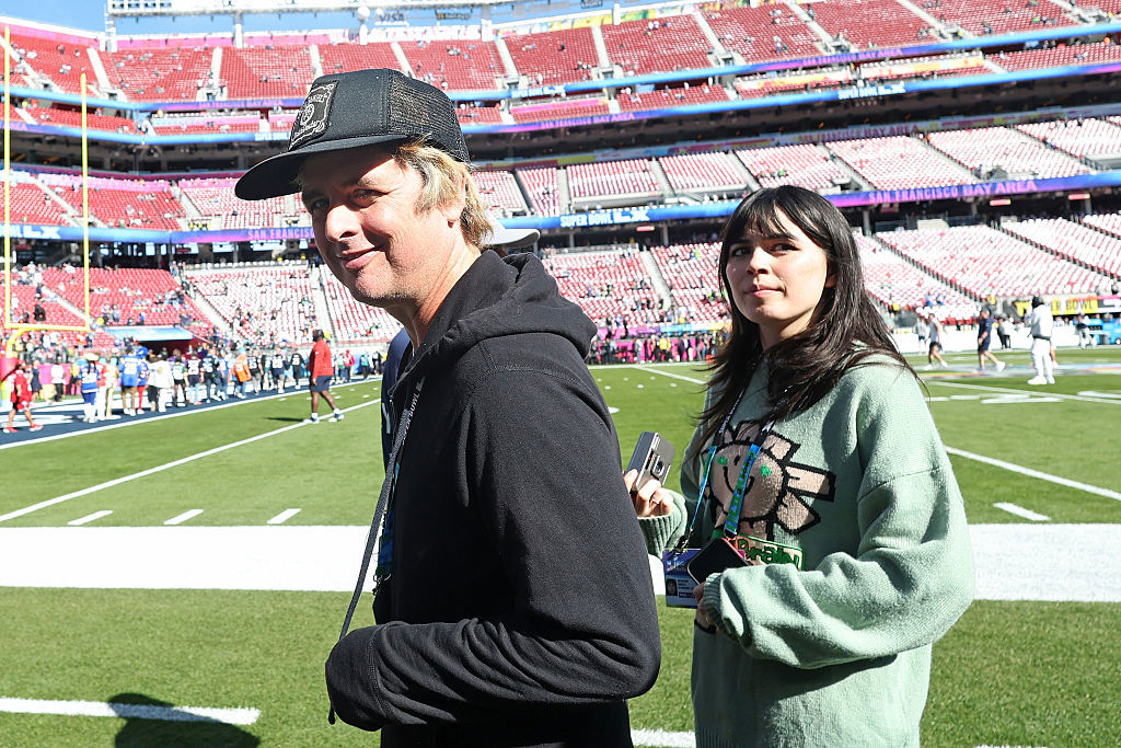 Billie Joe Armstrong (L) of Green Day looks on from the field before Super Bowl LX between the Seattle Seahawks and the New England Patriots at Levi's Stadium on February 08, 2026 in Santa Clara, California.  
