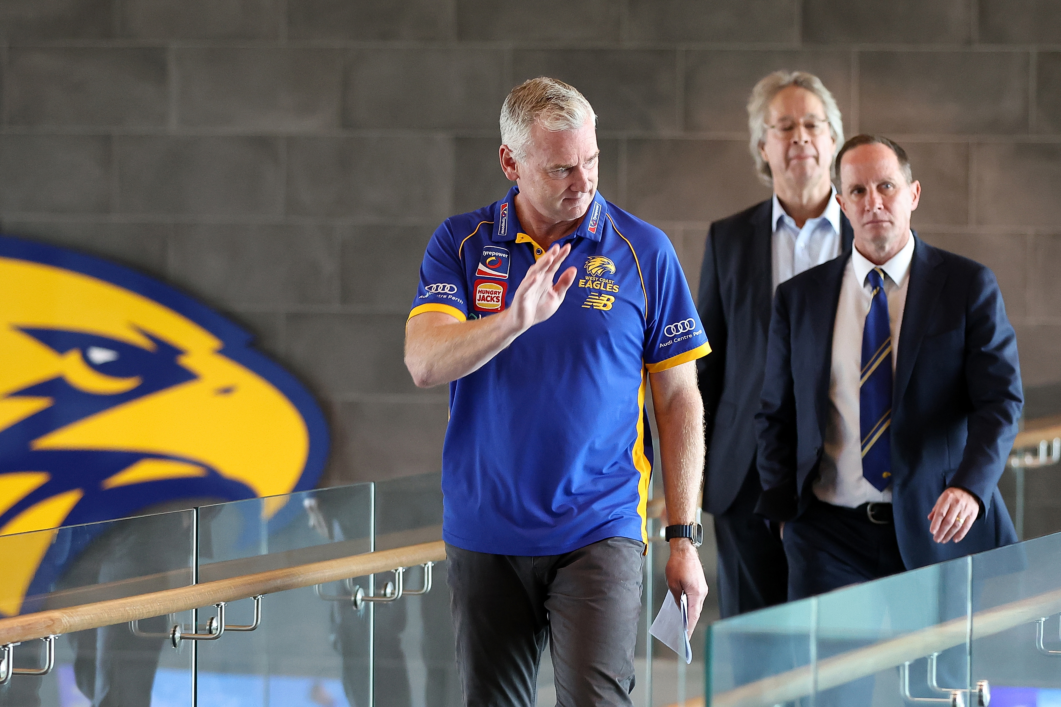 Adam Simpson waves to supporters while walking to his final press conference.