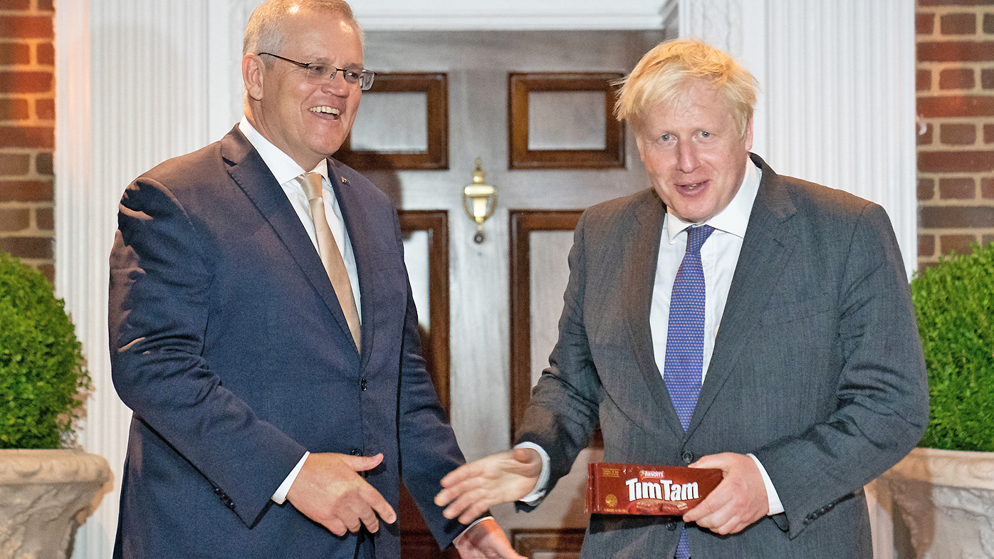 Prime Minister Boris Johnson is given a packet of the Australian snack, Tim Tams as he is greeted by his Australian counterpart, Scott Morrison on September 21, 2021 in Washington DC.