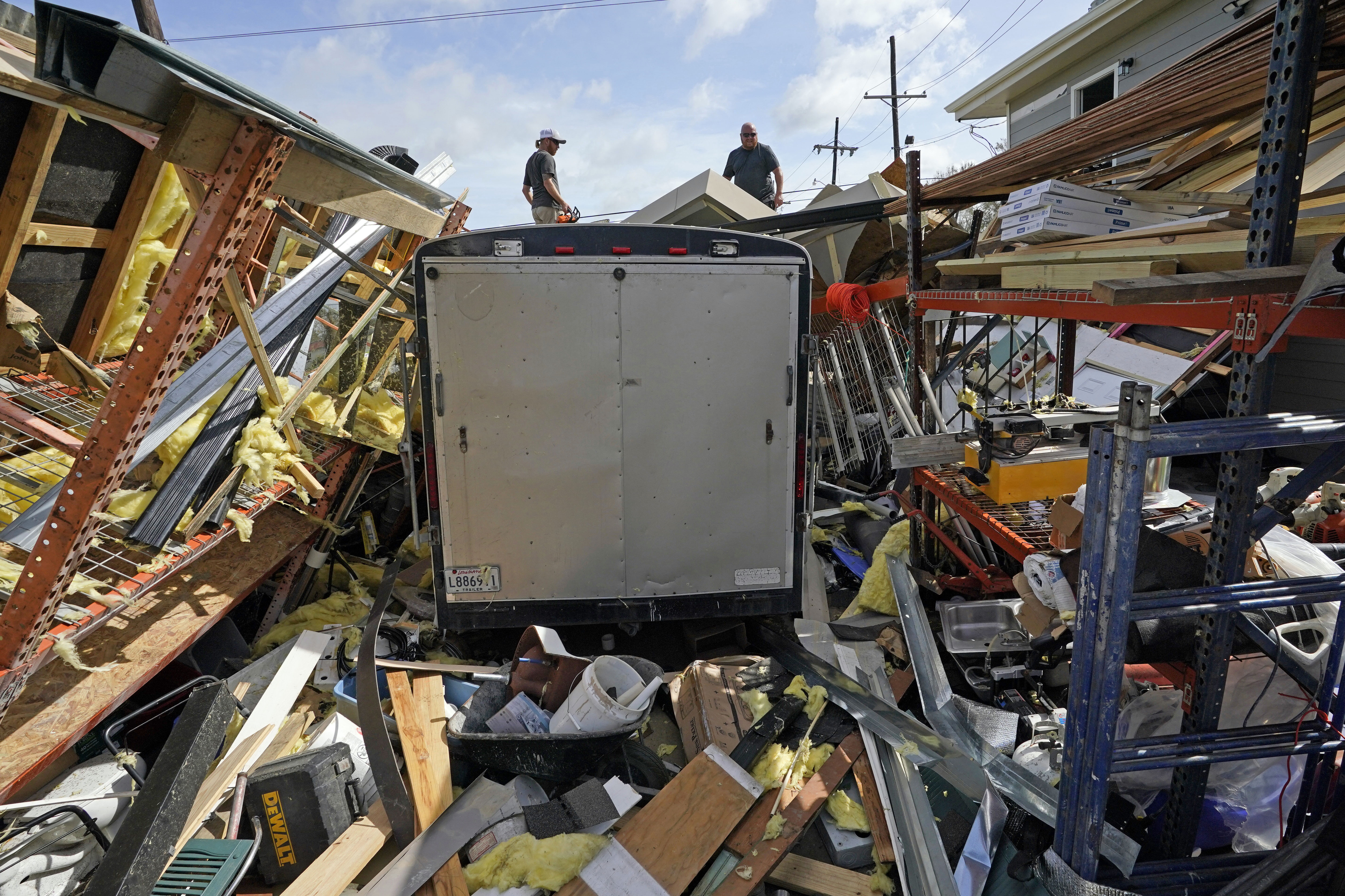 Jacob Hodges, right, and his brother Jeremy Hodges work to clear debris from their storage unit which was destroyed by Hurricane Ida.