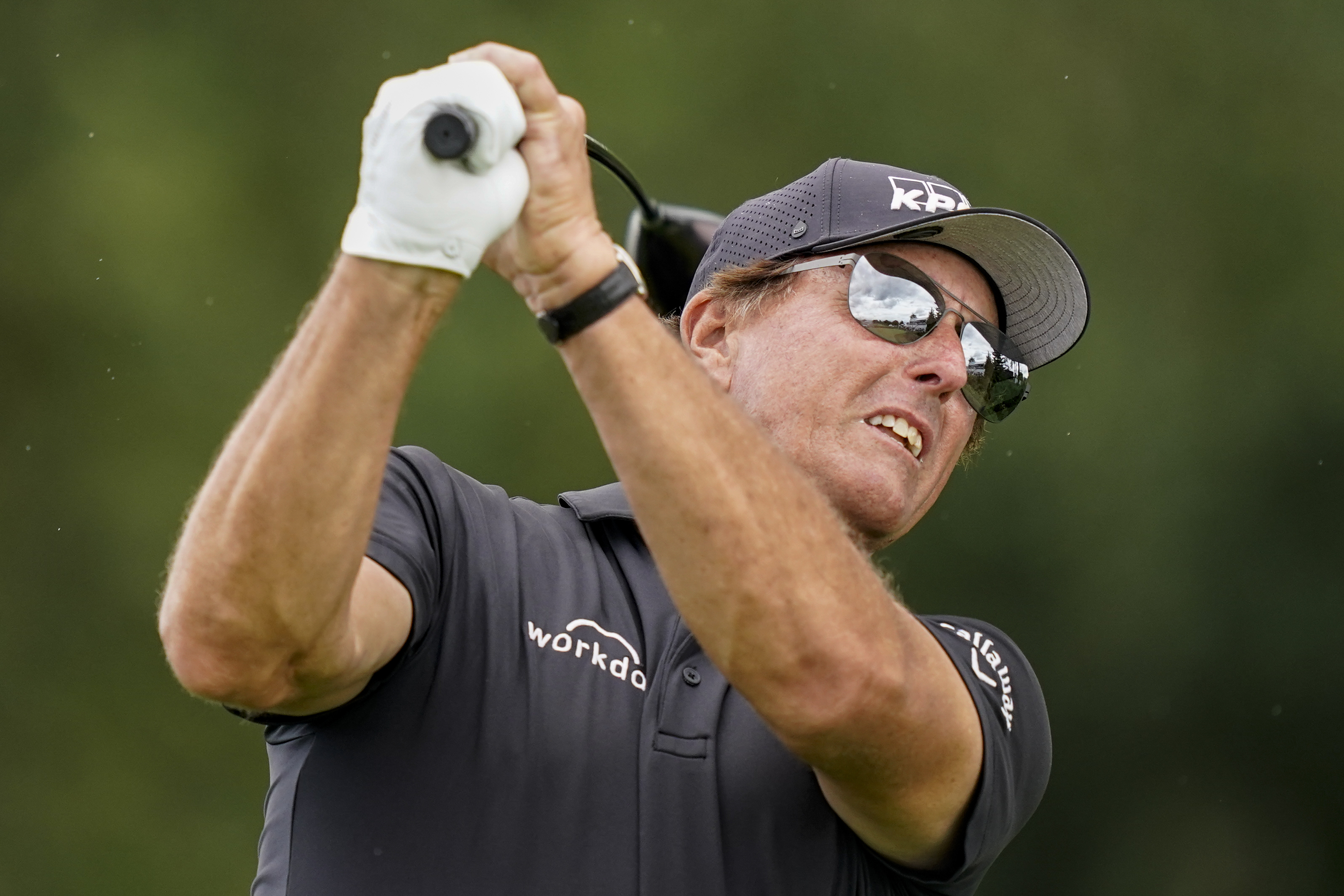 Phil Mickelson watches his shot off the 16th tee in the first round of play at the Northern Trust golf tournament.