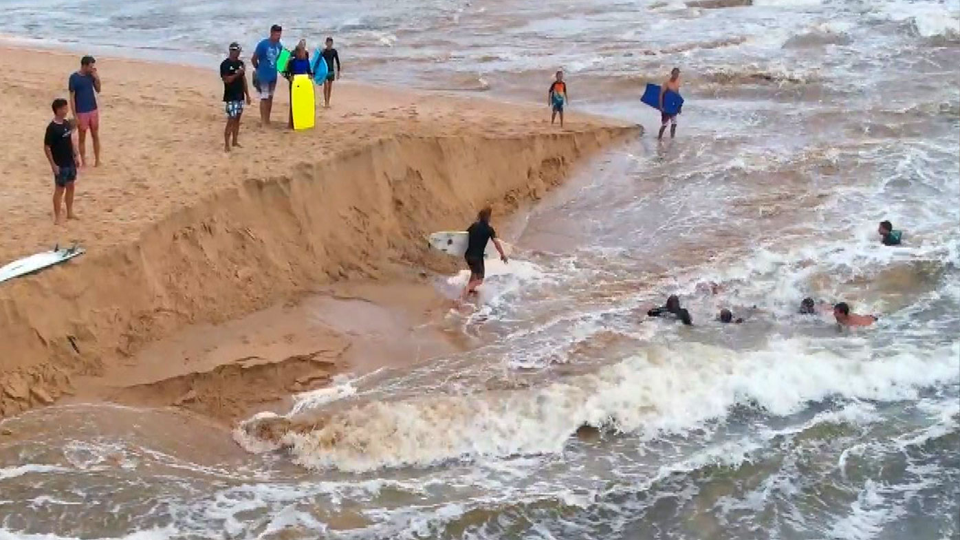 A group of Dee Why surfers have been hailed "heroes" after saving a man being swept out to sea during the city's wild weather.